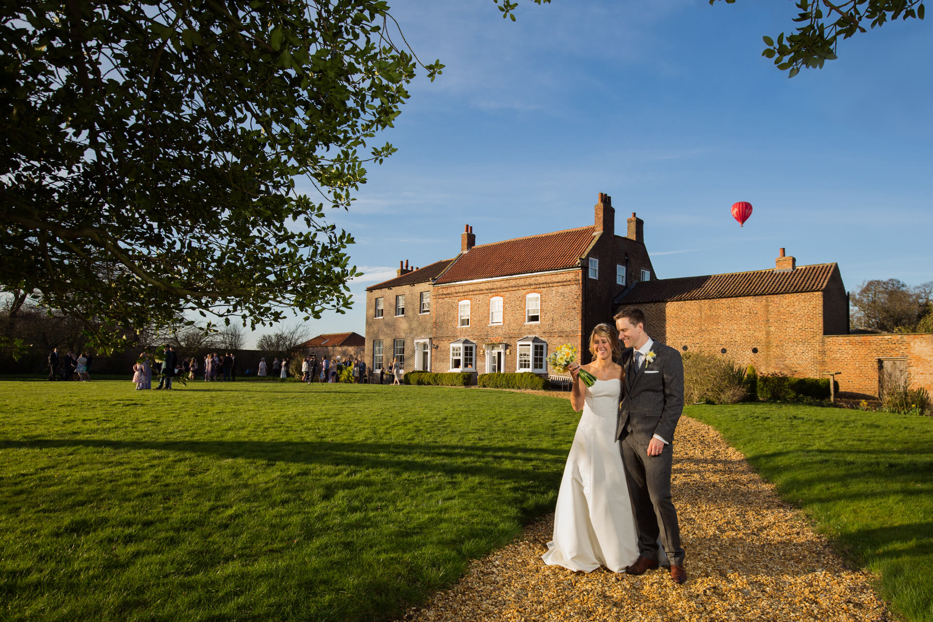 Couple at countryside wedding at Hornington Manor, hot air balloon in sky.