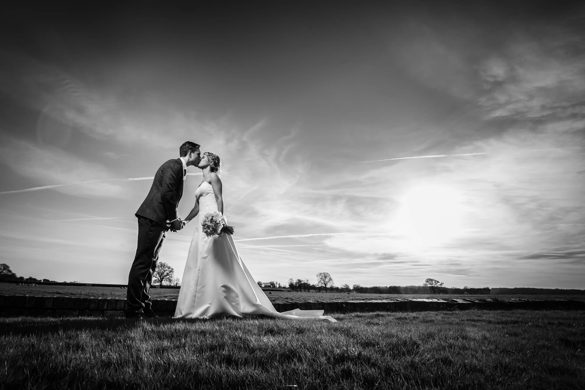 Bride and groom kissing in countryside wedding scene at Hornington Manor