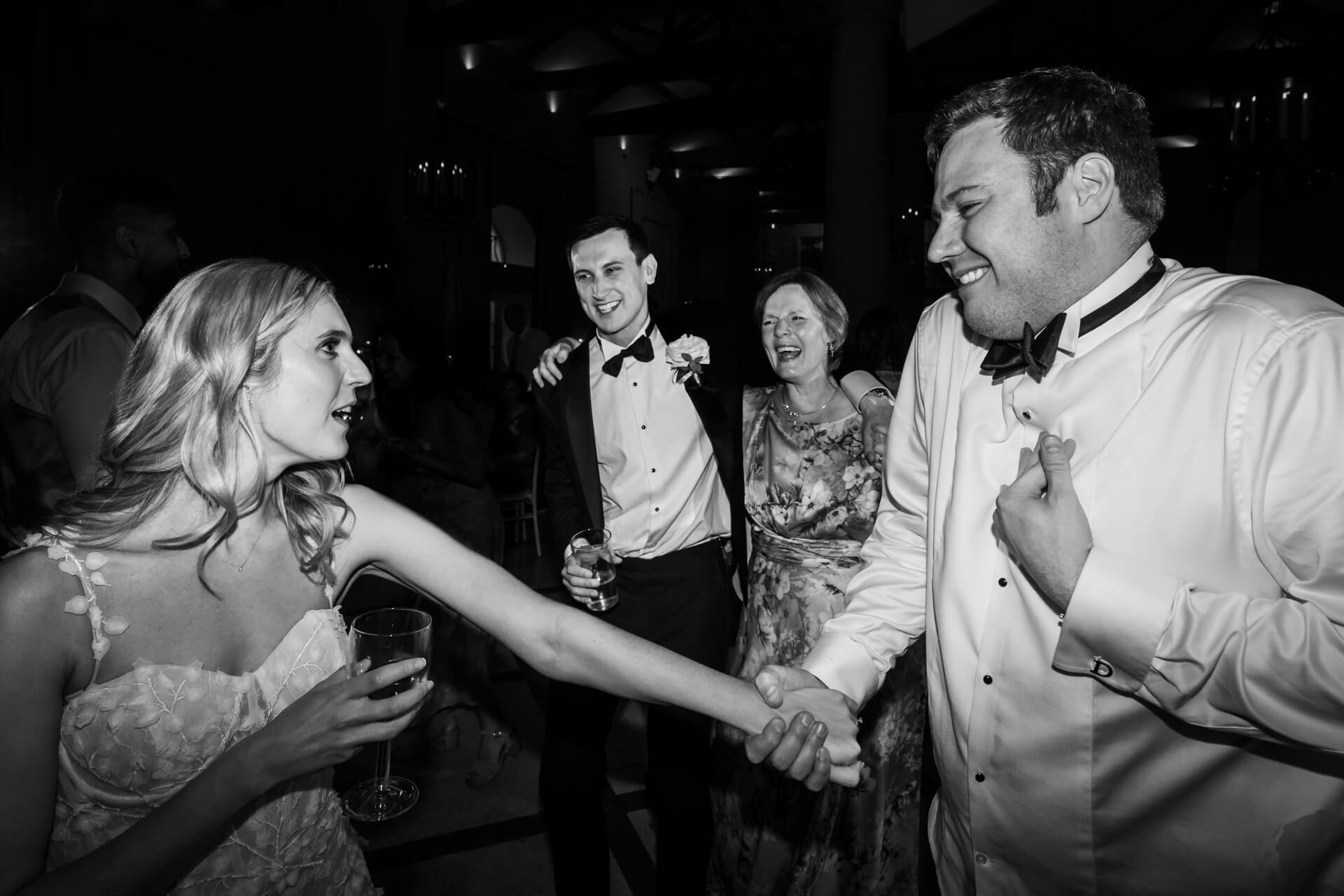 Guests enjoying dance at black-tie wedding reception.