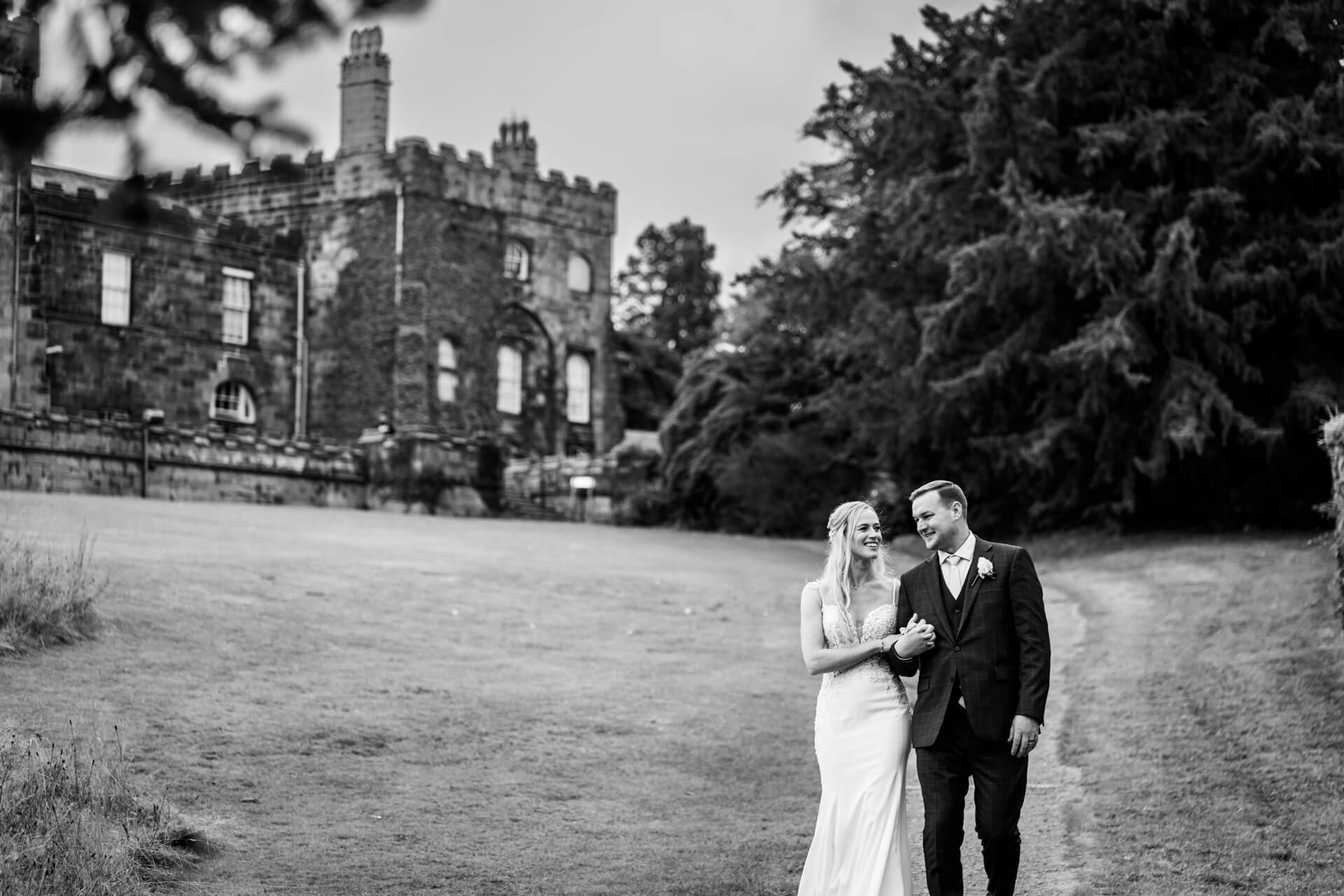 Couple walking outside Ripley Castle after wedding.