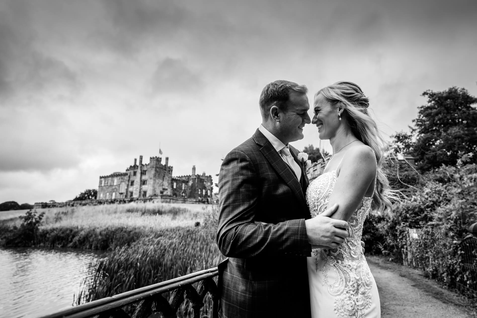 Bride and groom smiling together in front of Ripley Castle