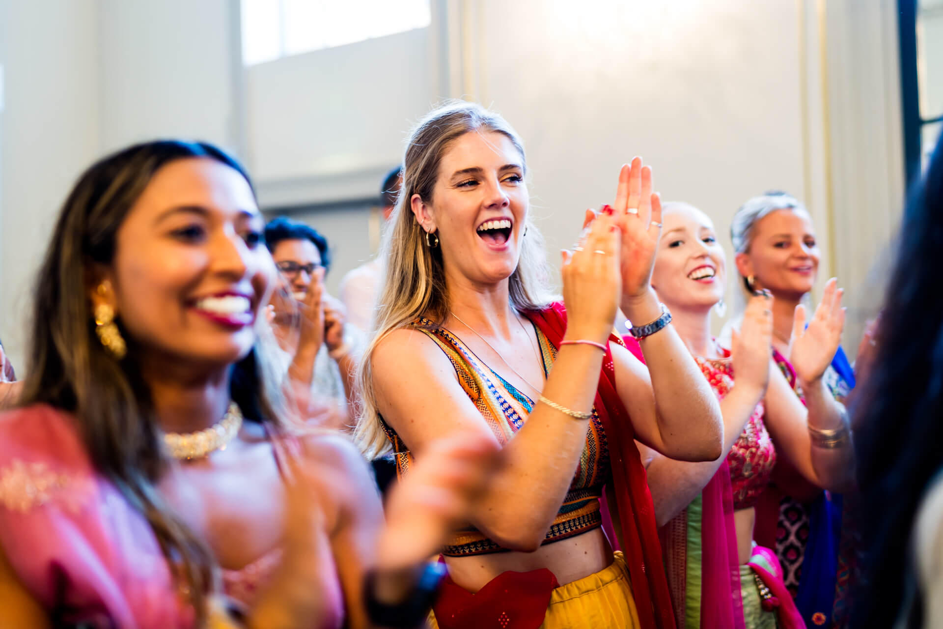 Group of guests joyfully clapping during the wedding ceremony