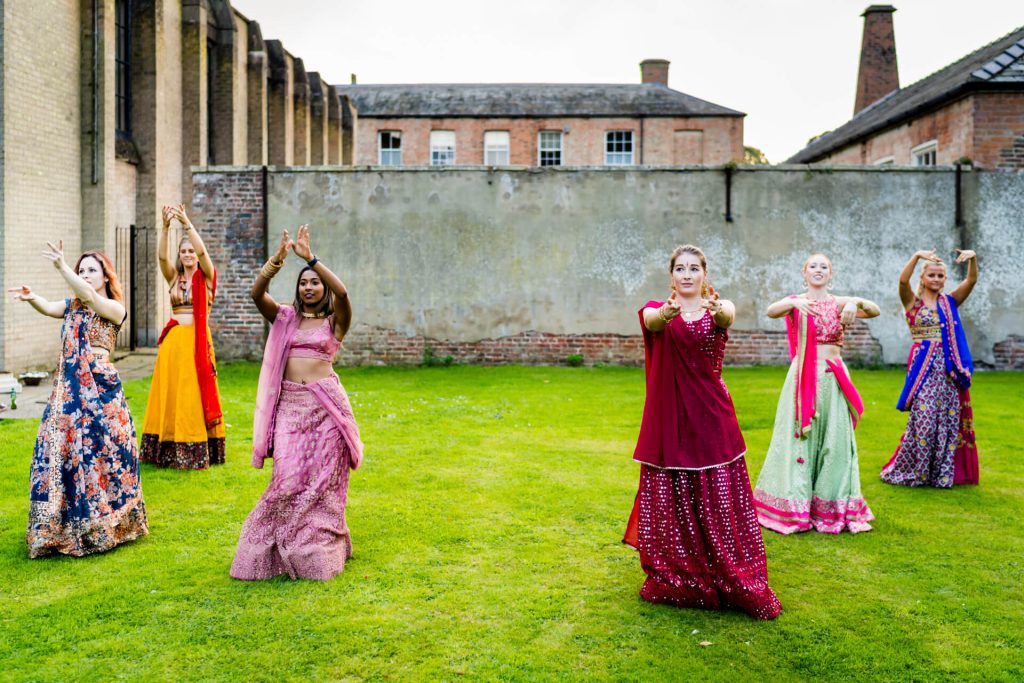 Women performing traditional Indian dance outdoors.