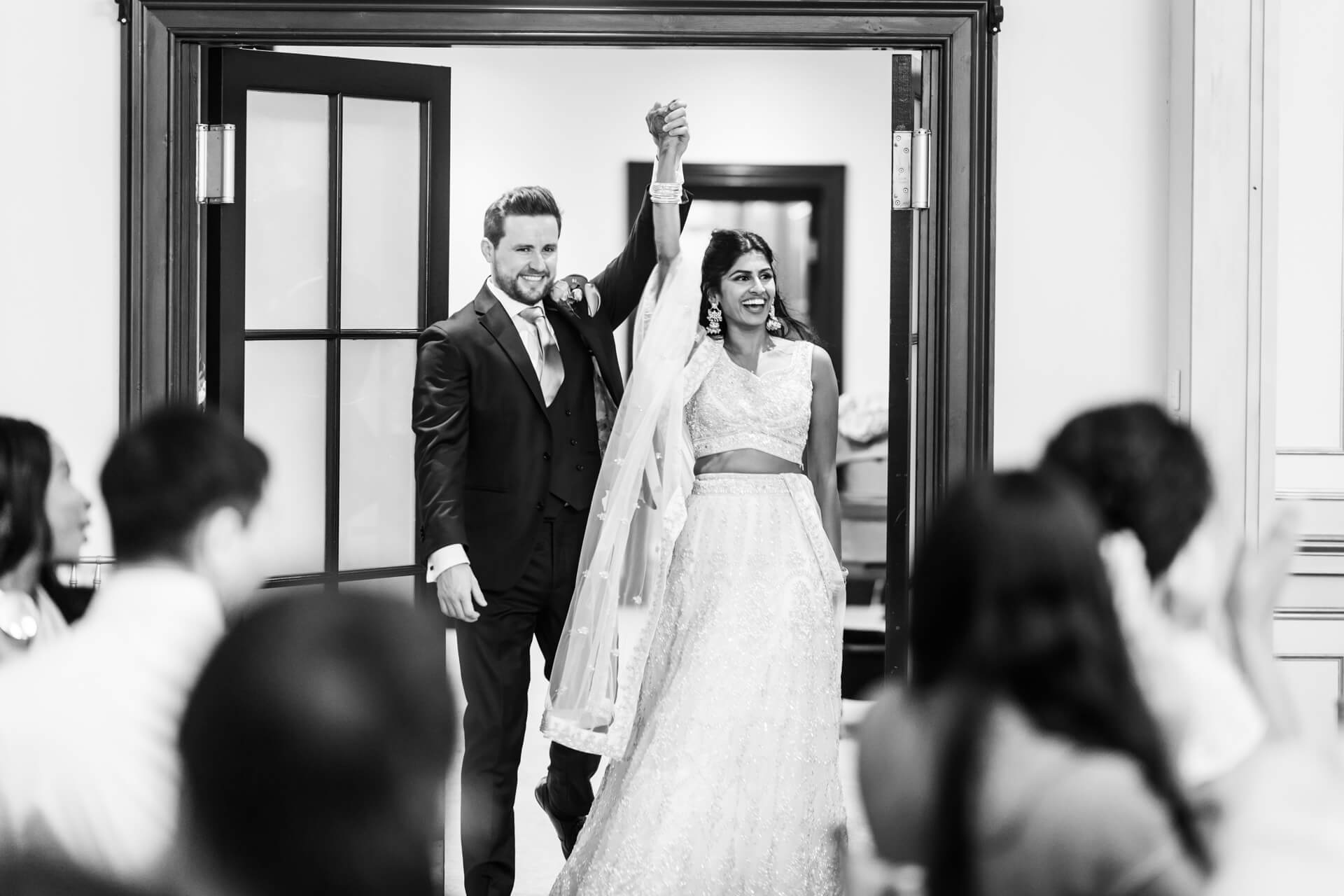 Joyful couple entering their wedding reception