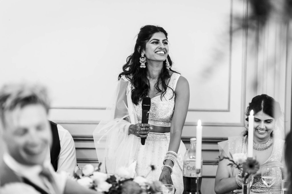 Joyful bride giving speech at wedding reception