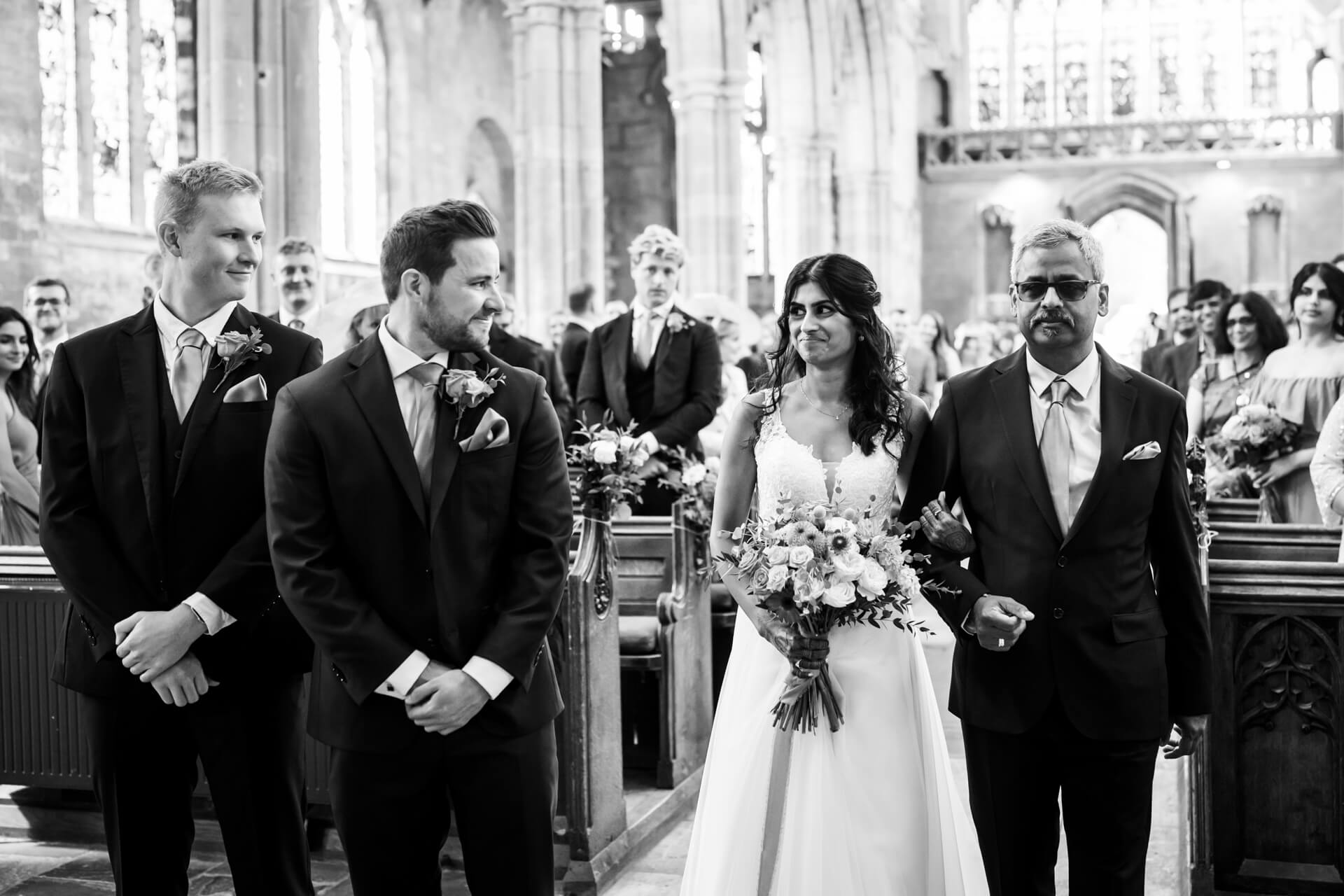 Bride meeting the groom at the top of the church aisle.