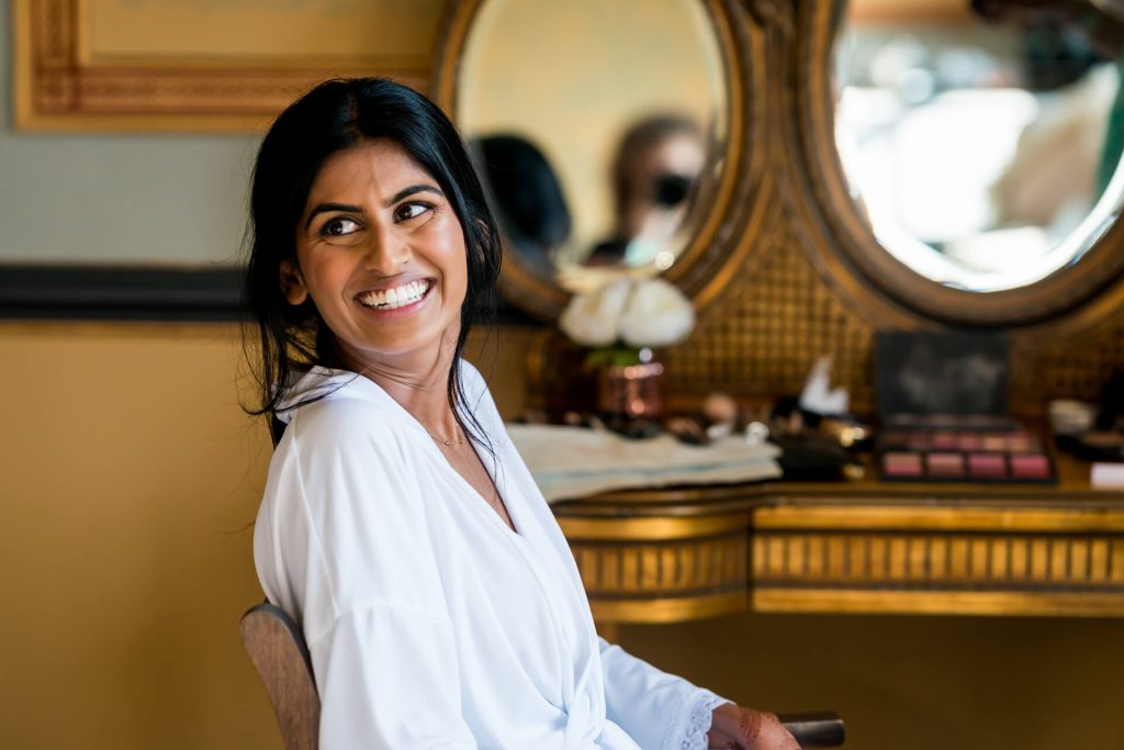 bride smiling in elegant makeup room.