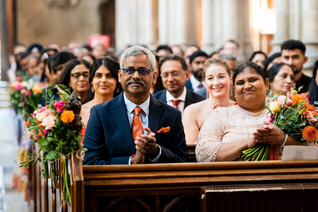 Guests clapping during wedding ceremony in church.