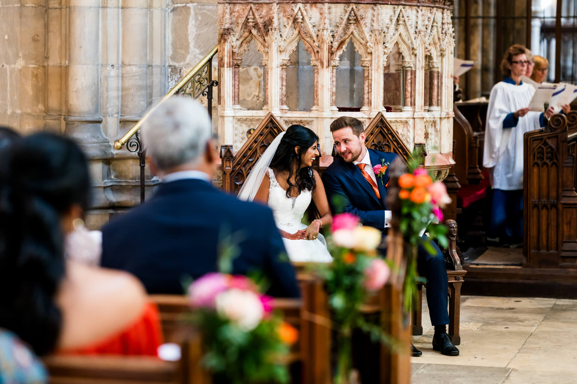 Bride and groom smiling in church wedding ceremony.