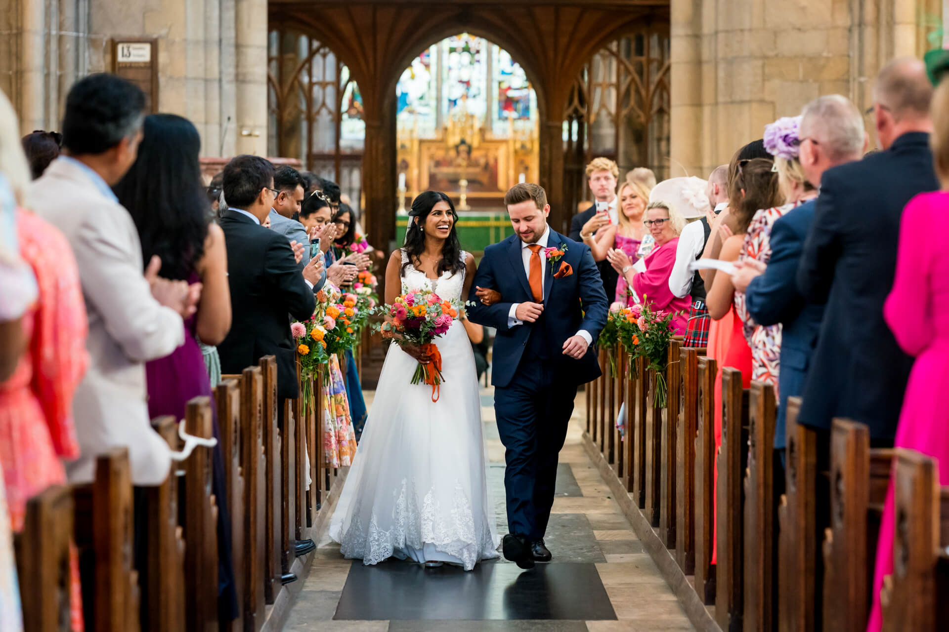 Bride and groom walking down the aisle at wedding.
