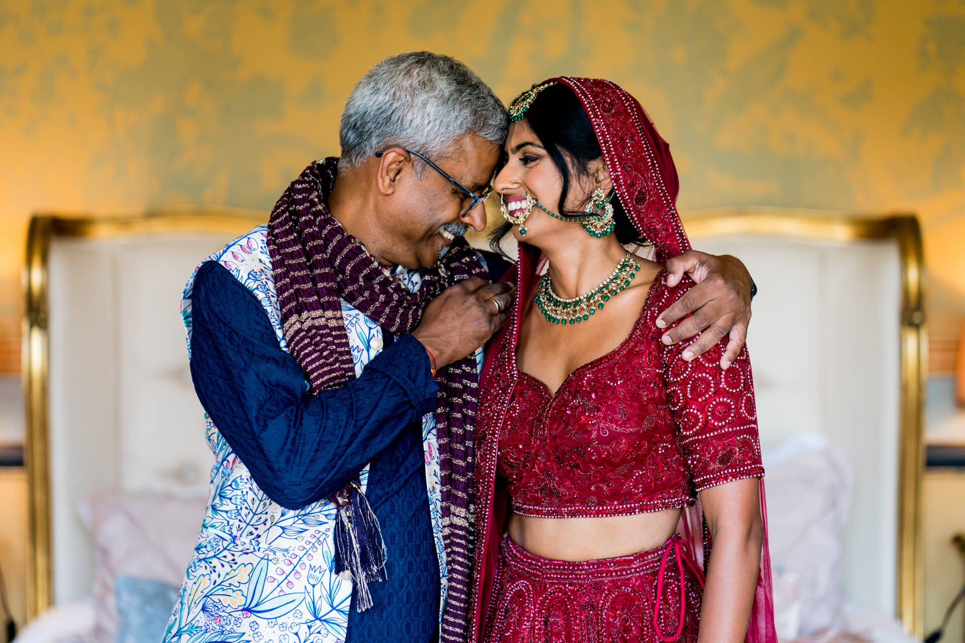 Bride and her father in traditional Indian wedding attire, embracing