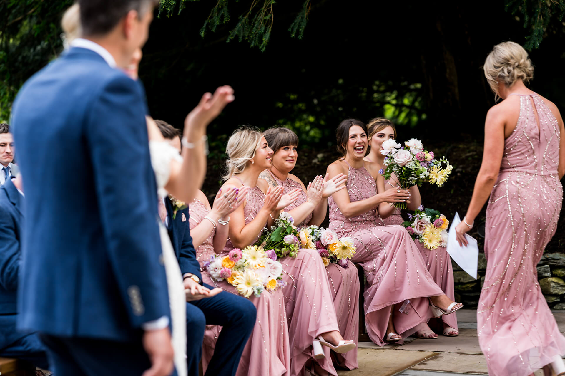 Bridesmaids in pink laughing during wedding ceremony at the Towhead Estate