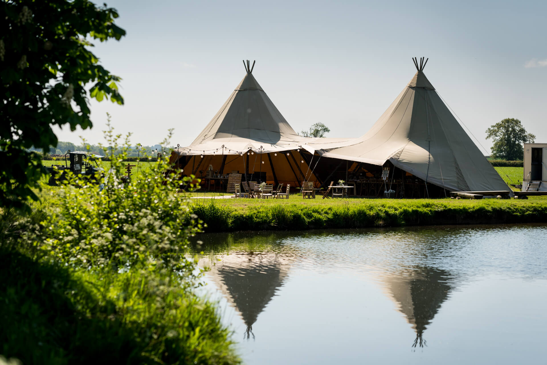 Riverside tipi event venue in countryside setting