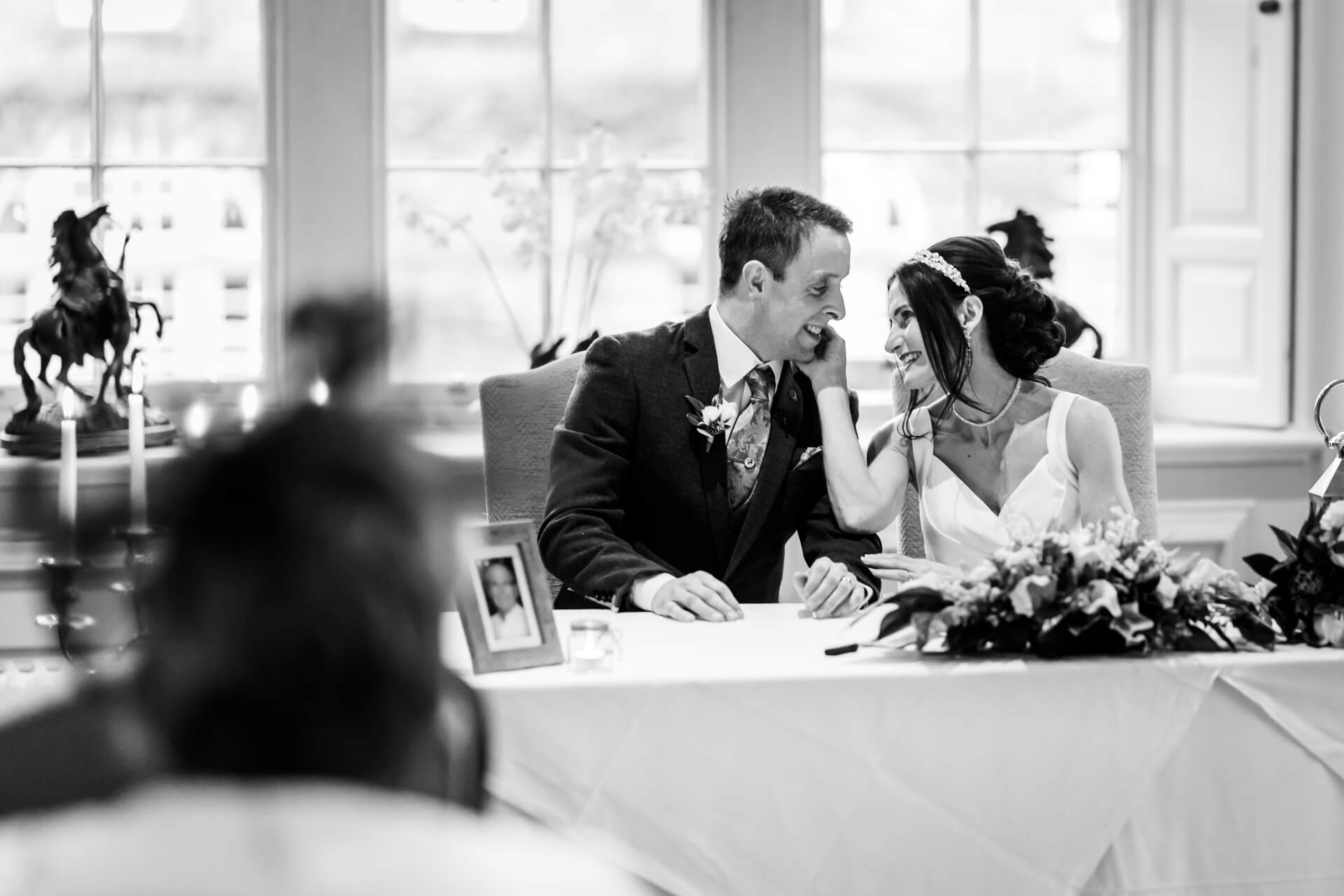 Bride and groom smiling, signing marriage register.