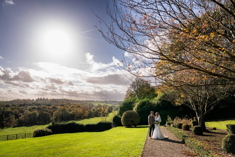 Wedding couple in sunny autumn countryside scenery at Wood Hall Hotel