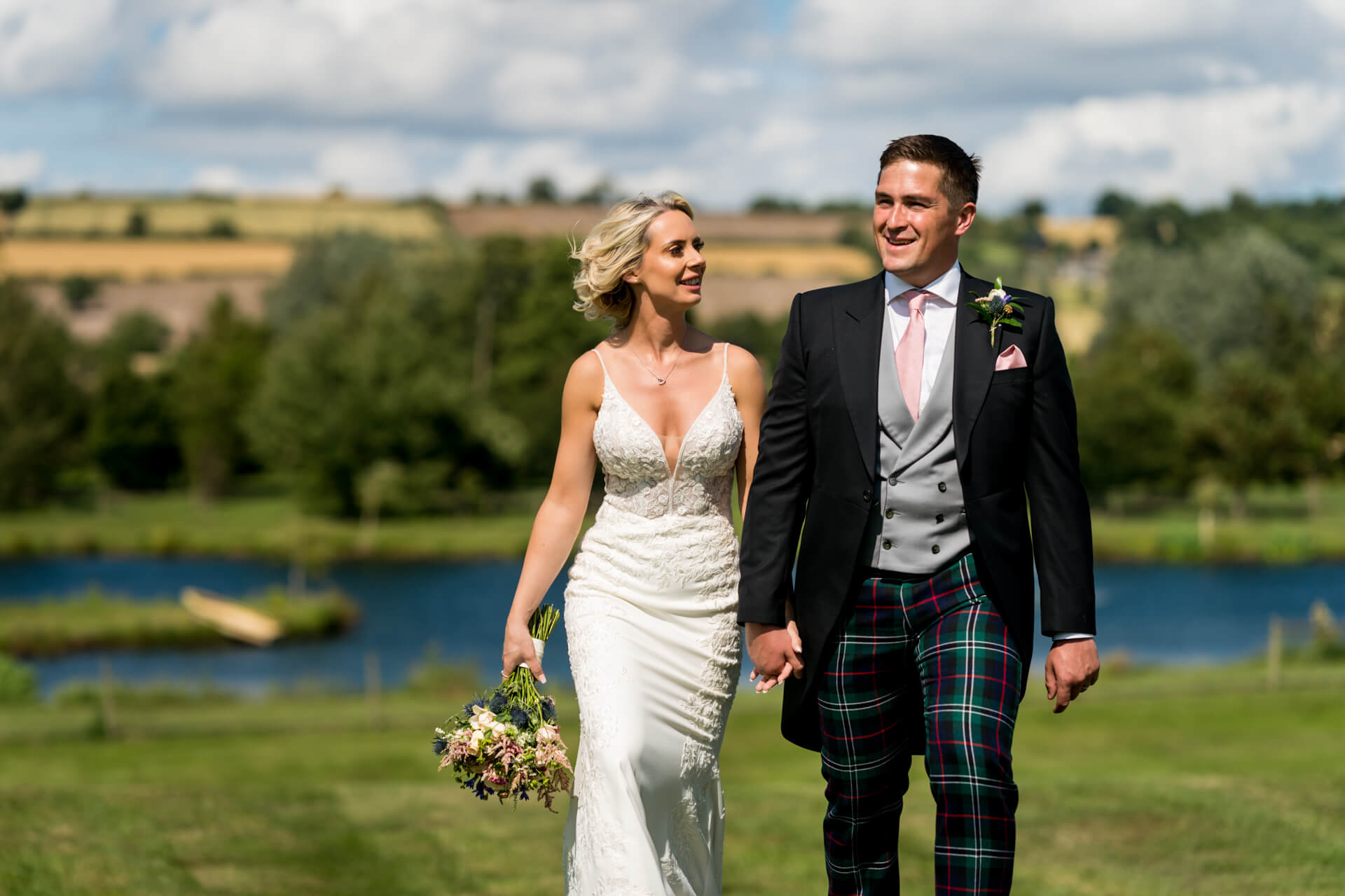 Bride and groom walking by lake