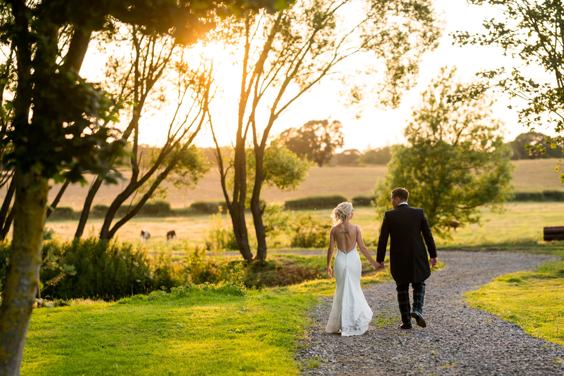 Couple walking in sunset after wedding at The Yorkshire Wedding Barn