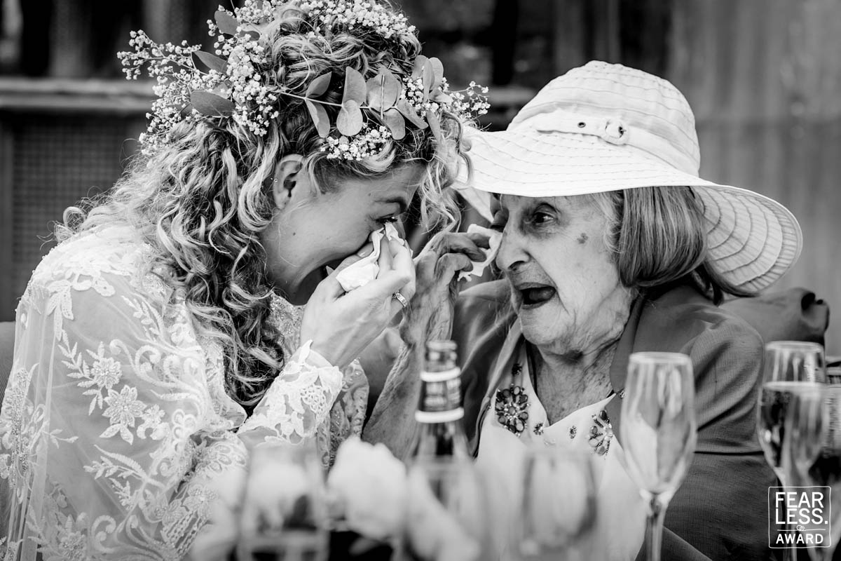 Emotional wedding moment between bride and elderly woman.