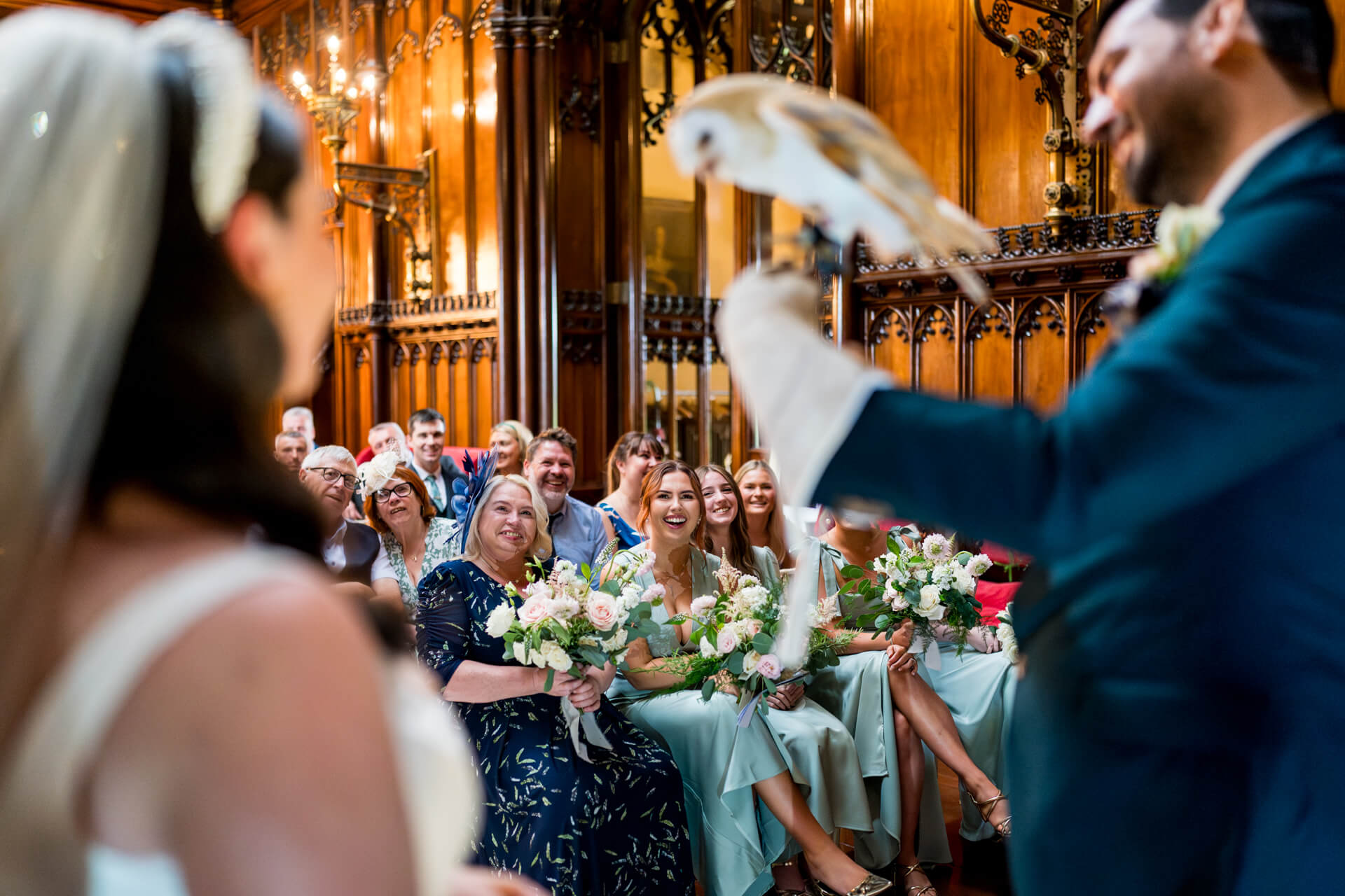 Wedding owl ring bearer surprising guests in ornate hall