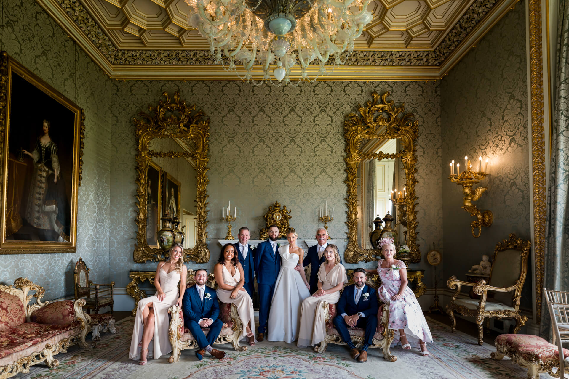 Elegant wedding group in ornate room at Allerton Castle with vintage decor