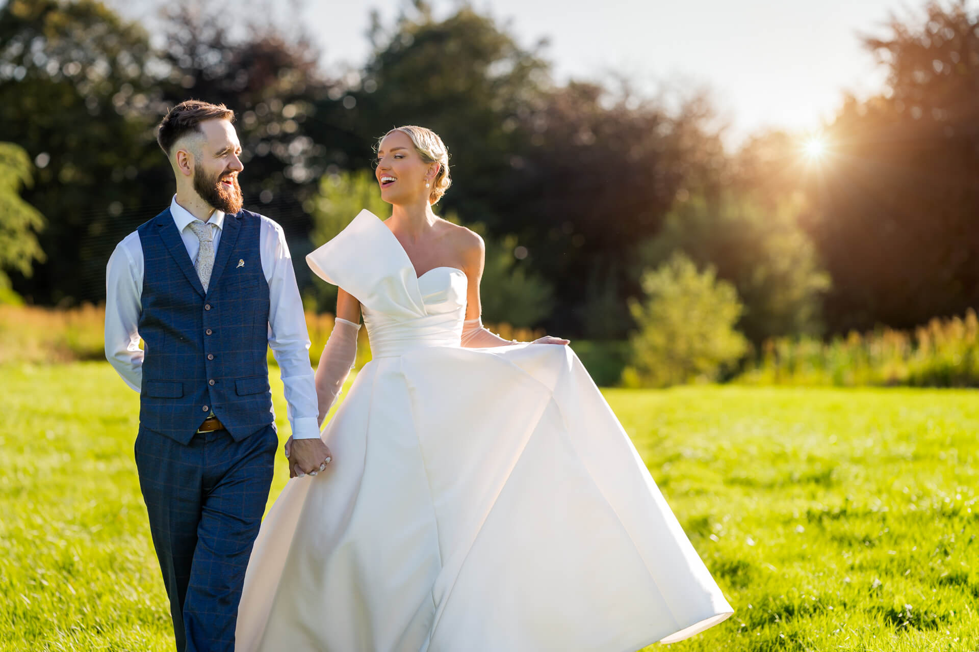 Joyful newlyweds walking in sunlit park