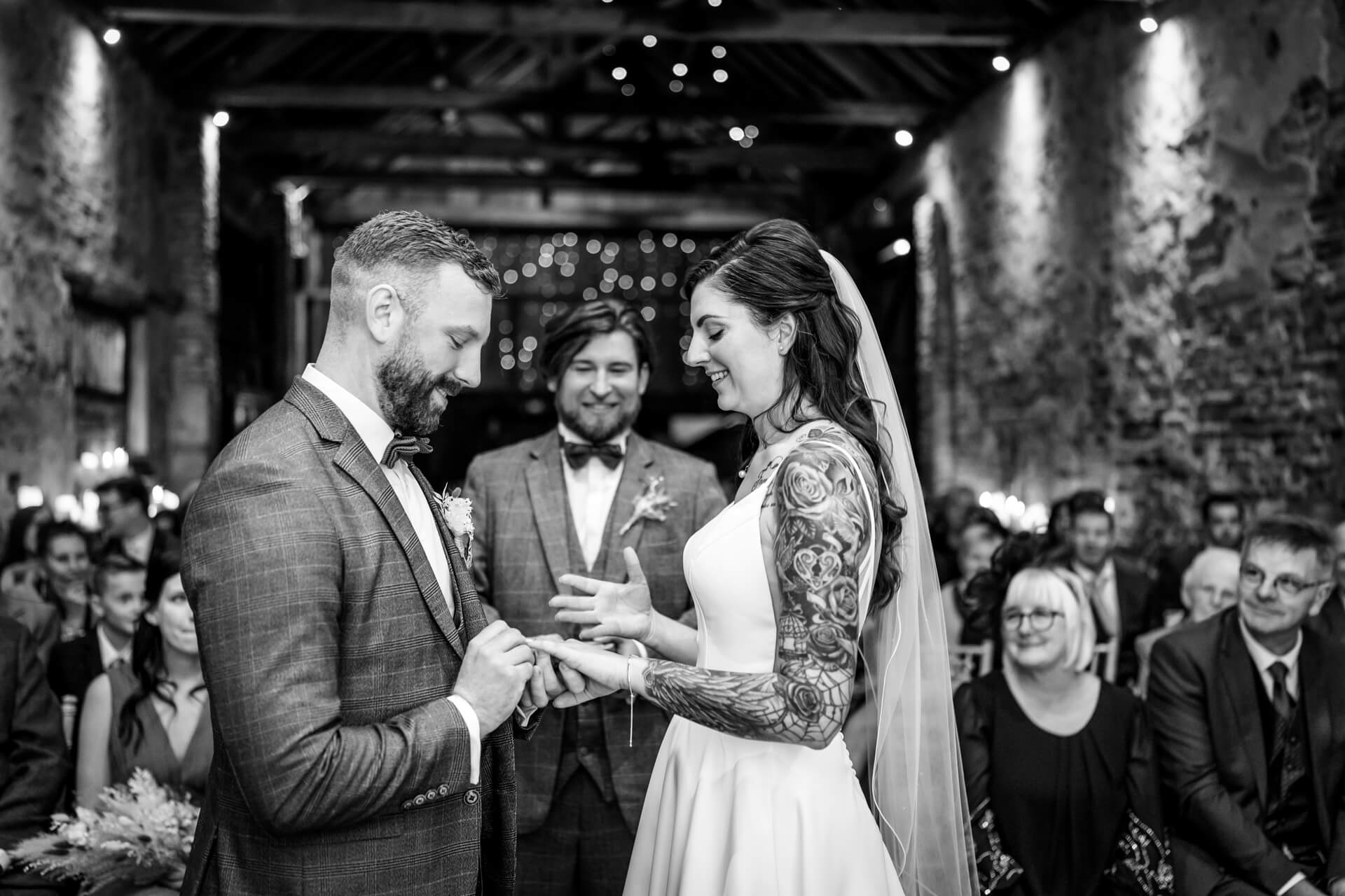 Bride and groom exchanging rings at The Normans wedding barn