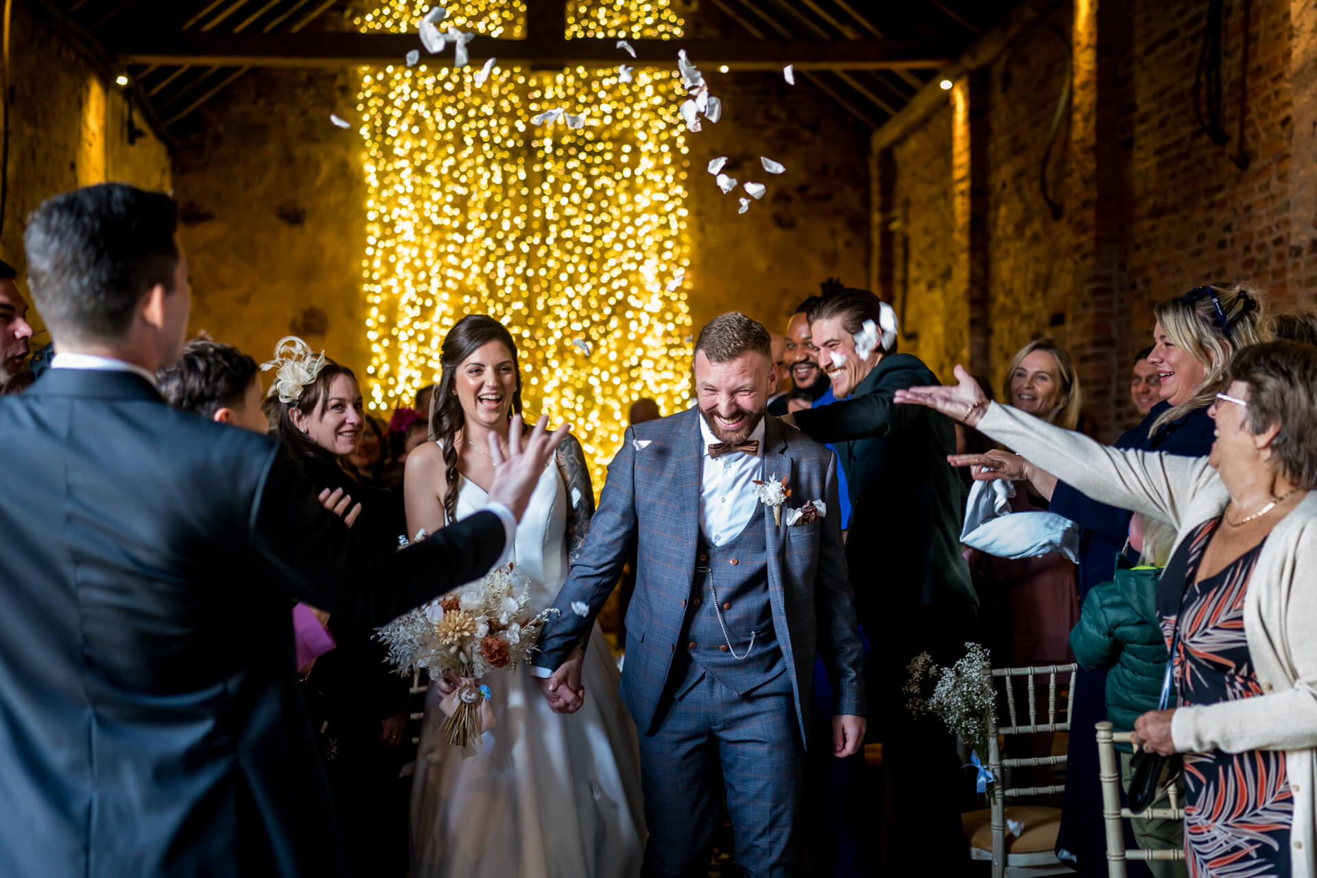 Joyful wedding reception with confetti and fairy lights at The Normans wedding barn