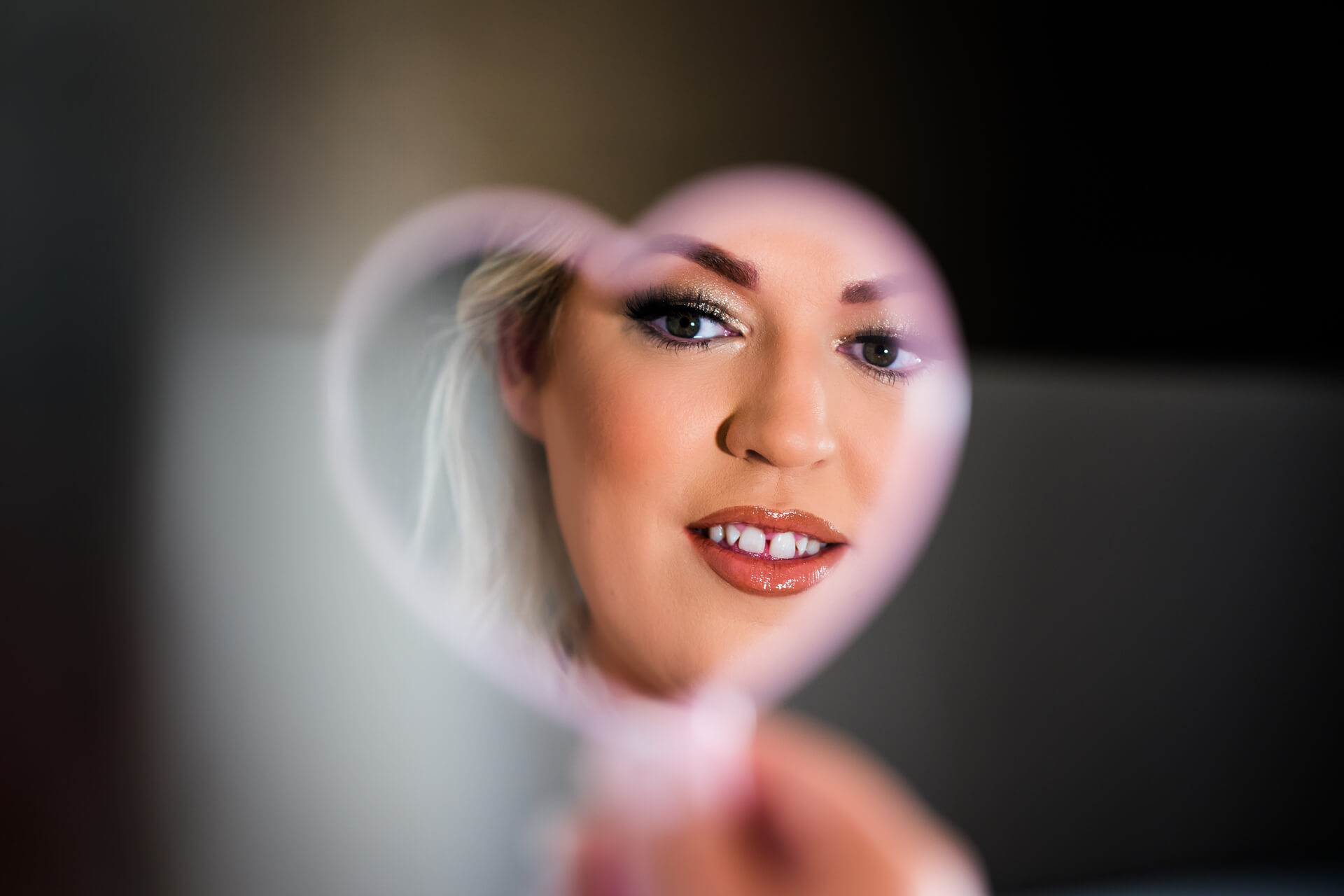 Bride looking in heart-shaped mirror