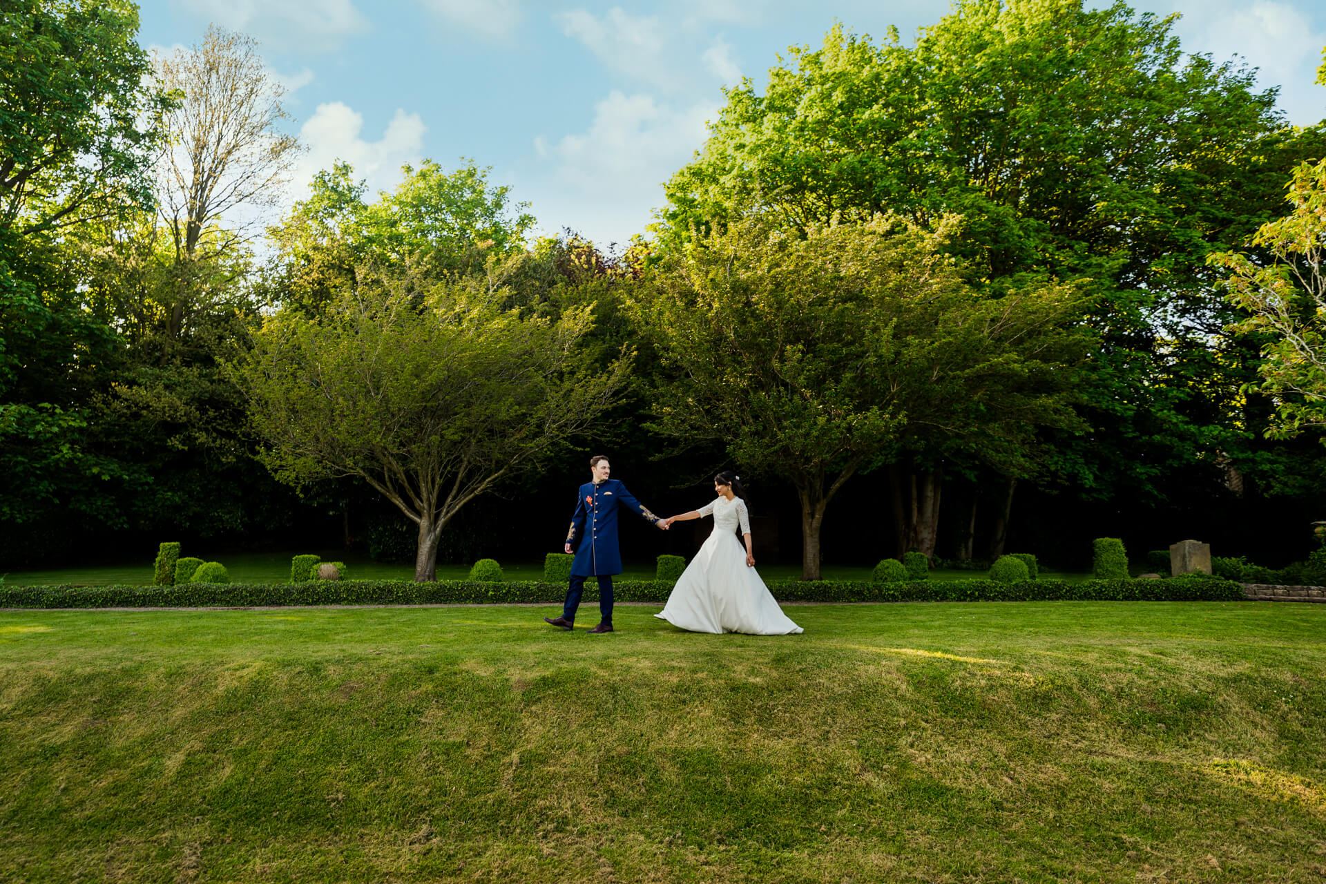 Couple holding hands in garden on sunny day at Woodall hotel