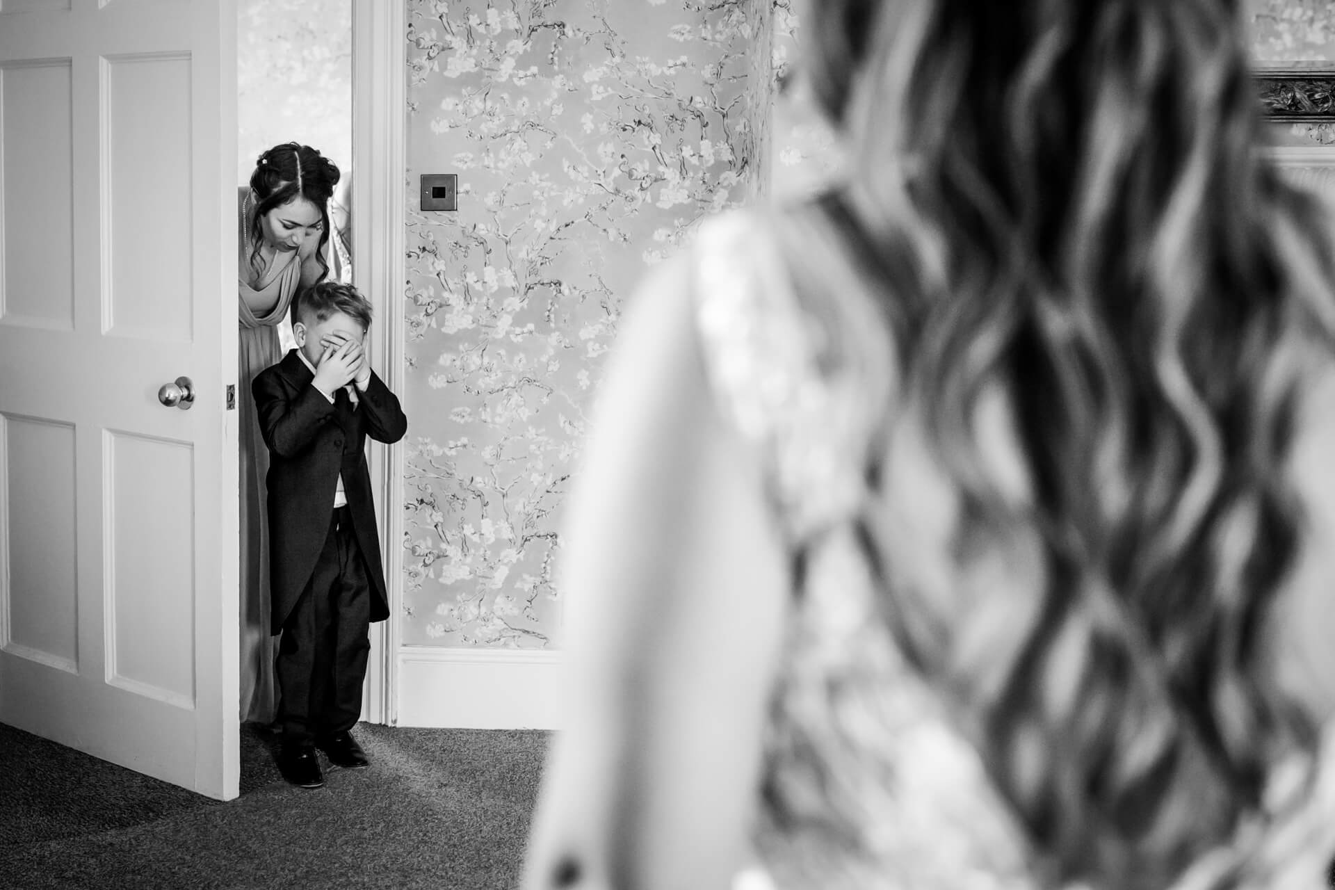 brides son entering room to see his mother, he has his hands over his eyes