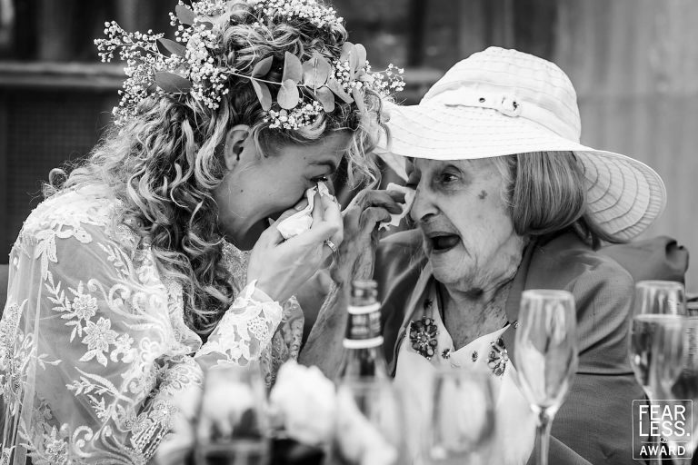 Bride crying with elderly woman at wedding