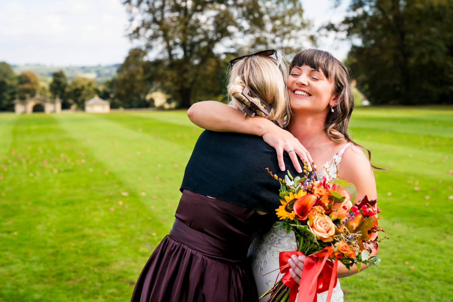 wedding guest embracing the bride at wedding with flowers