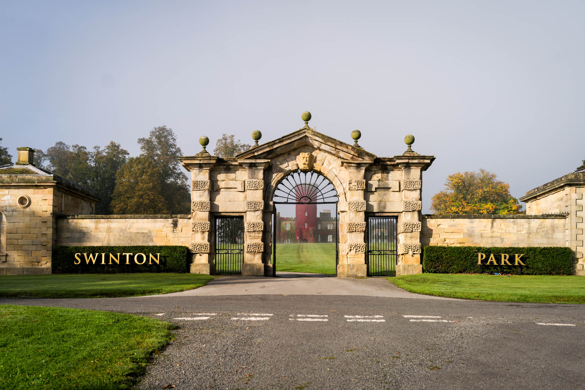 Swinton Park ornate gate with red building in background