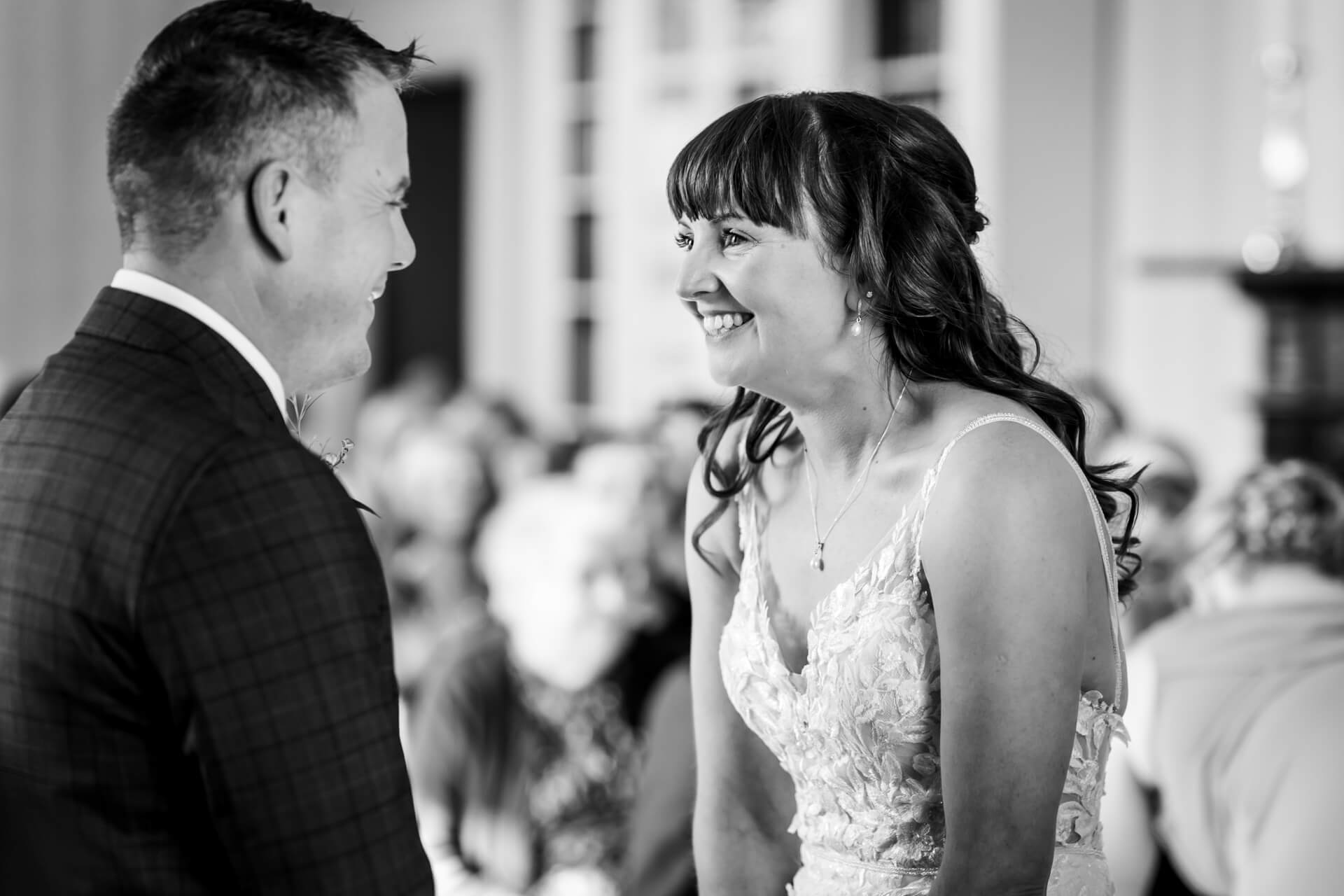 Joyful wedding couple sharing a laugh, black and white