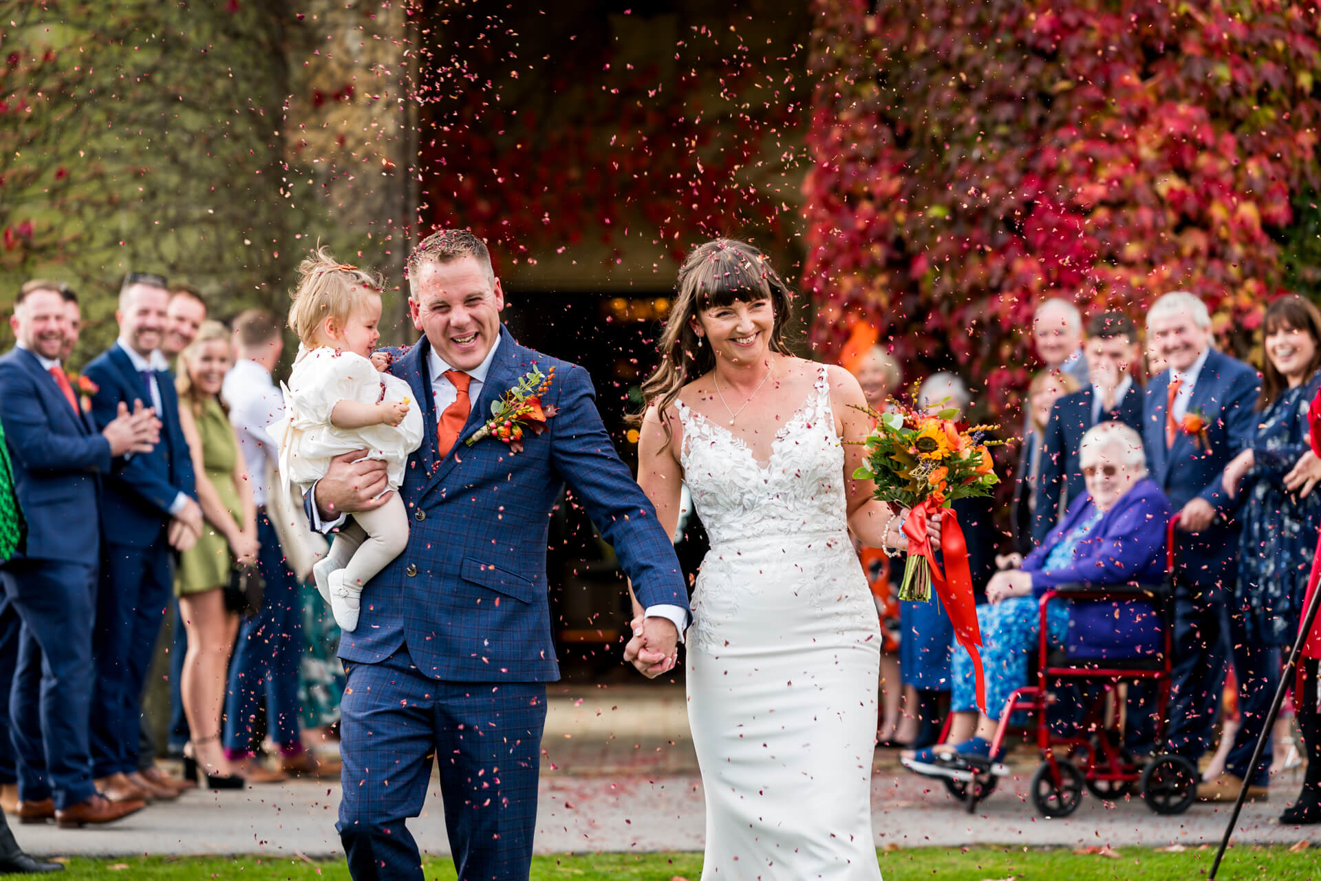 Wedding couple joyful confetti moment with guests at Swinton Park