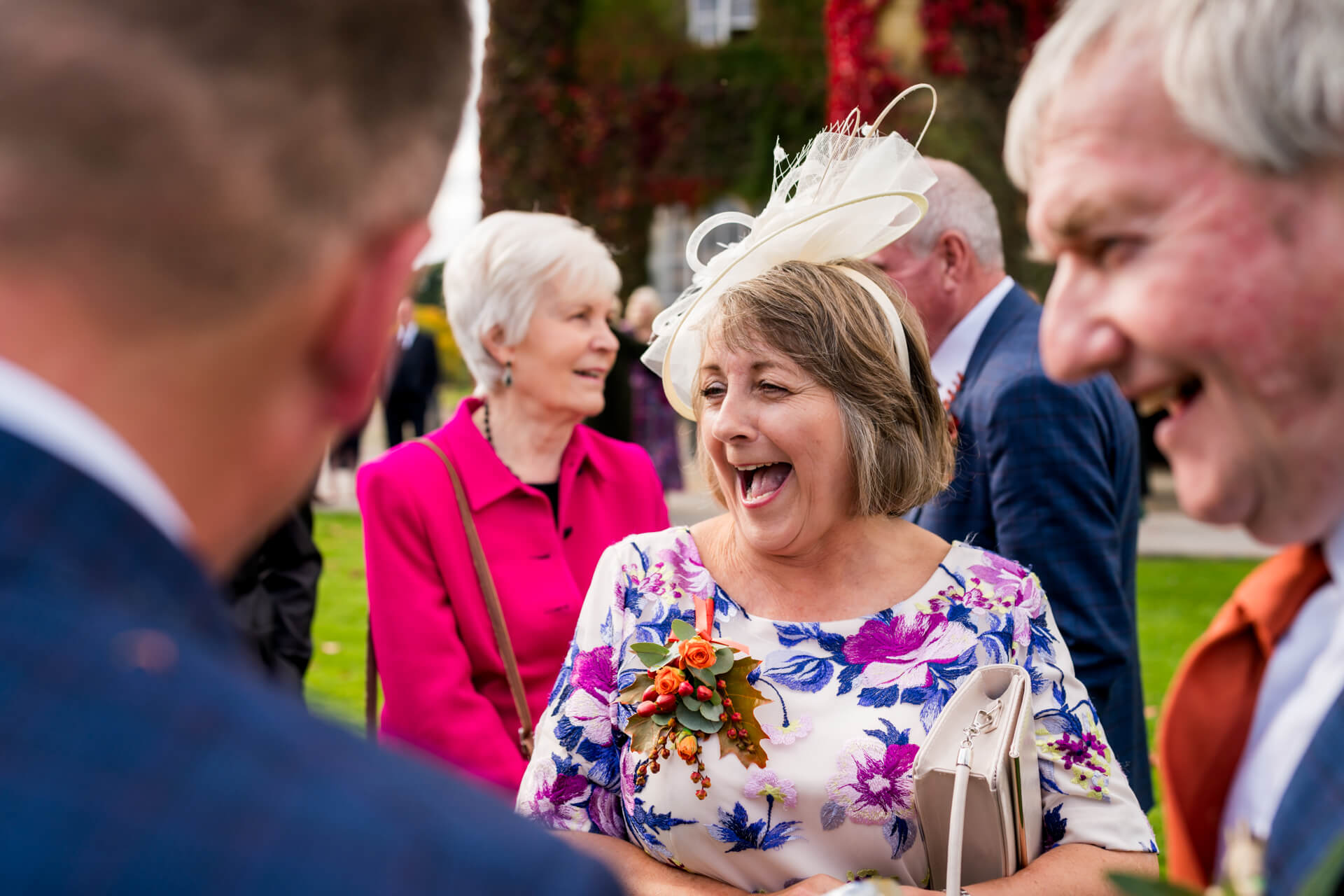 Joyful guests laughing at a garden wedding reception
