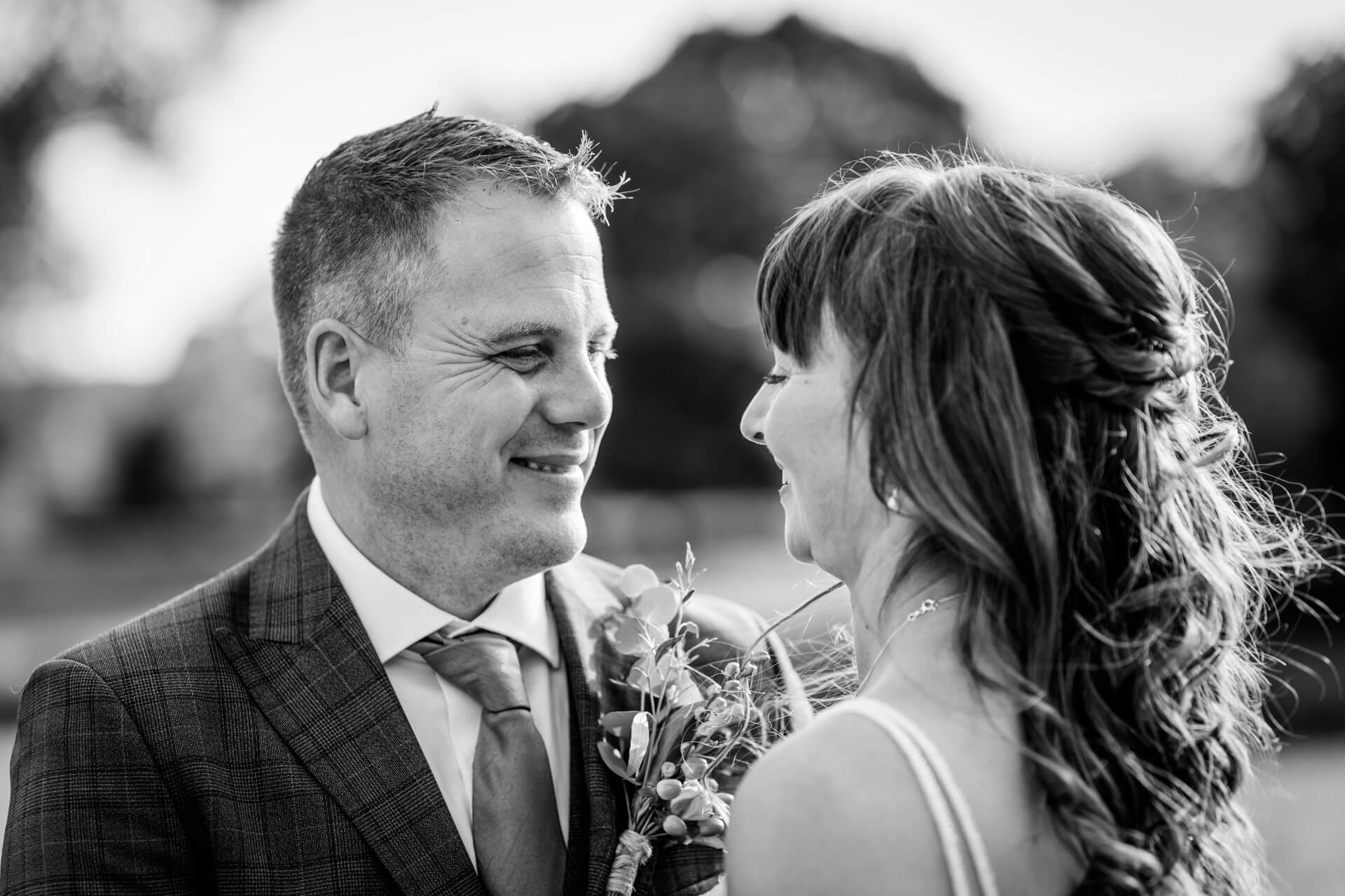 Couple smiling lovingly in black and white wedding photo