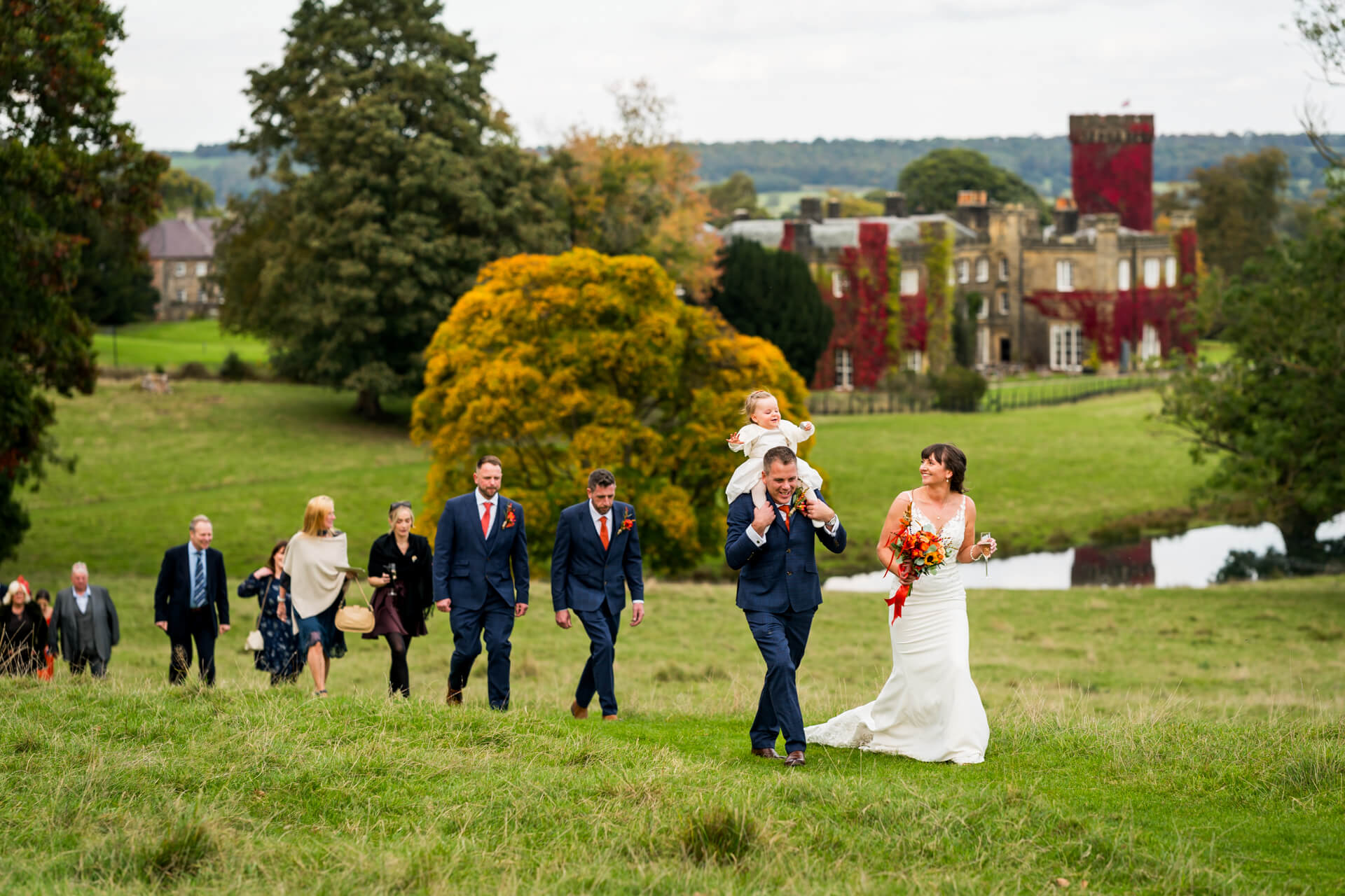 Wedding party walking near historic Swinton Park estate in countryside