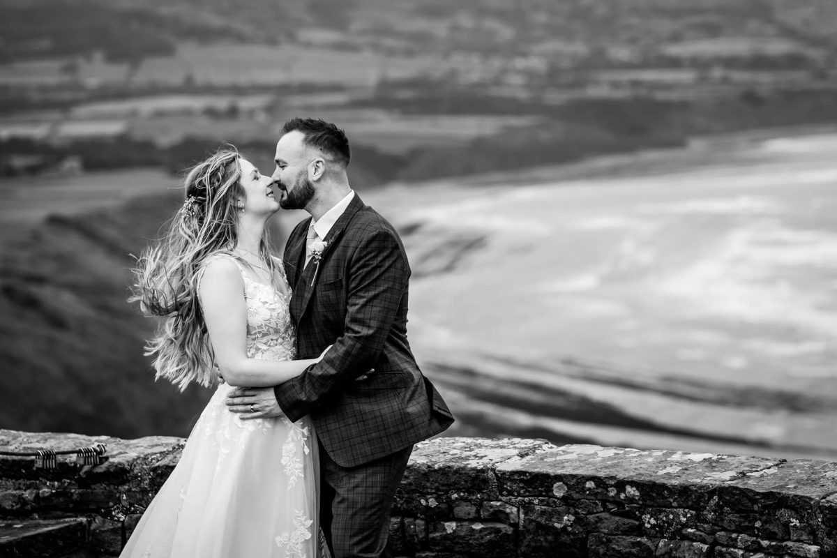 Bride and groom kissing outdoors with scenic backdrop