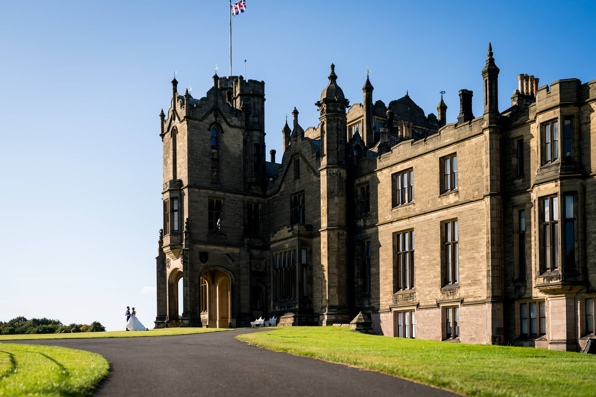 Couple standing together in front of Historic Allerton Castle