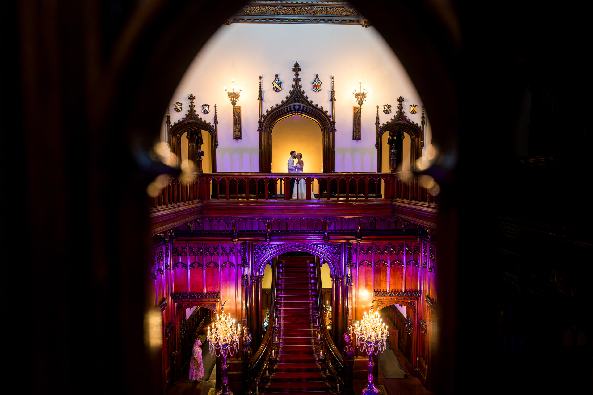 Couple kissing on ornate balcony at Allerton Castle with grand staircase