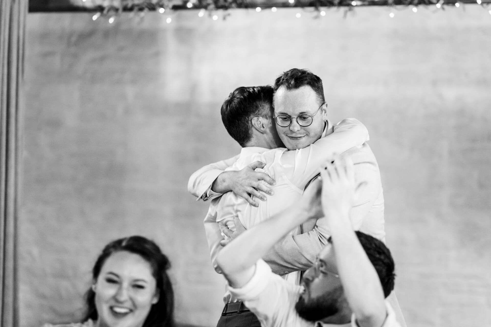 Two men joyfully hugging at celebration, black and white photo