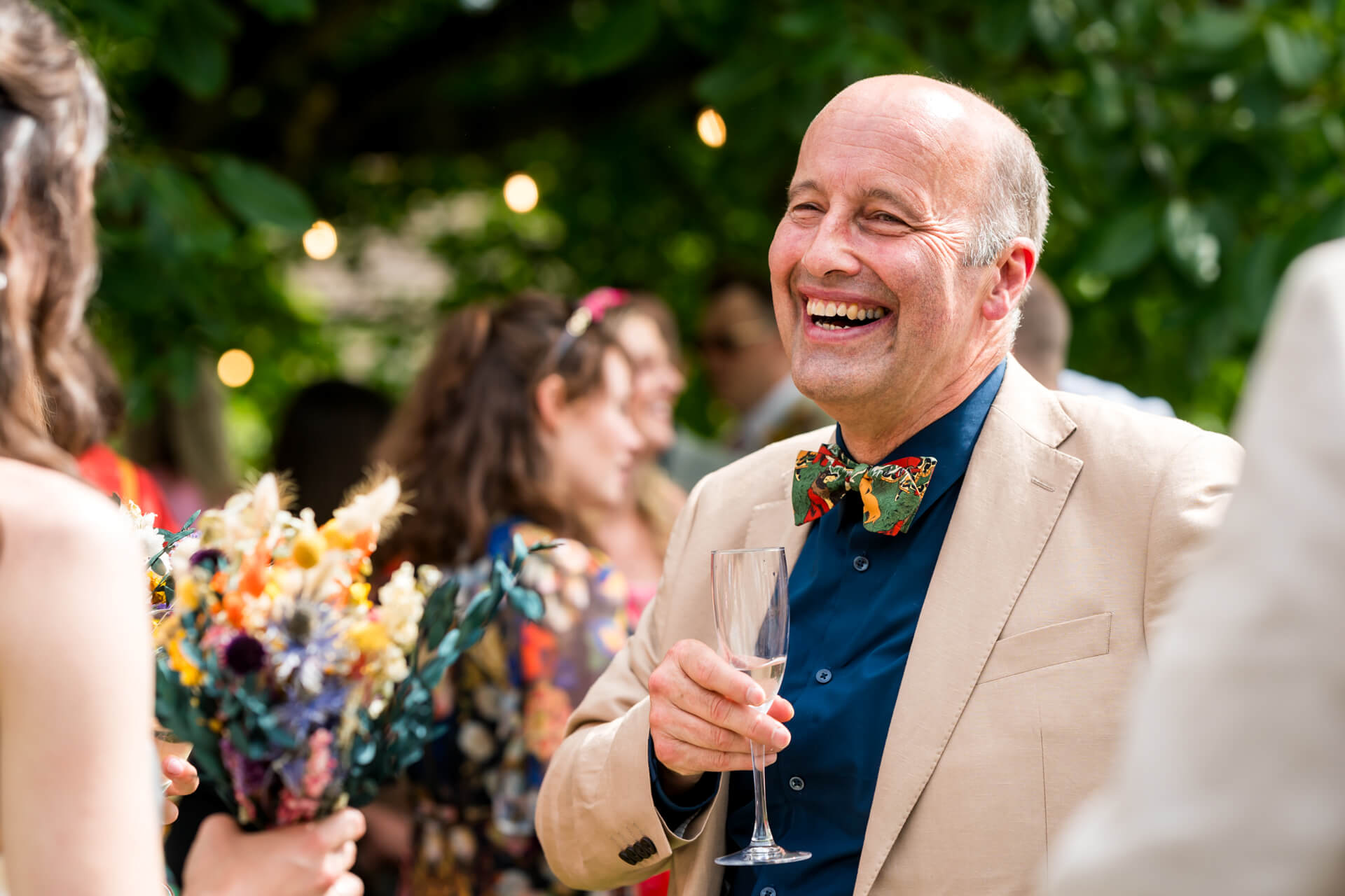 Joyful man at wedding garden party holding champagne