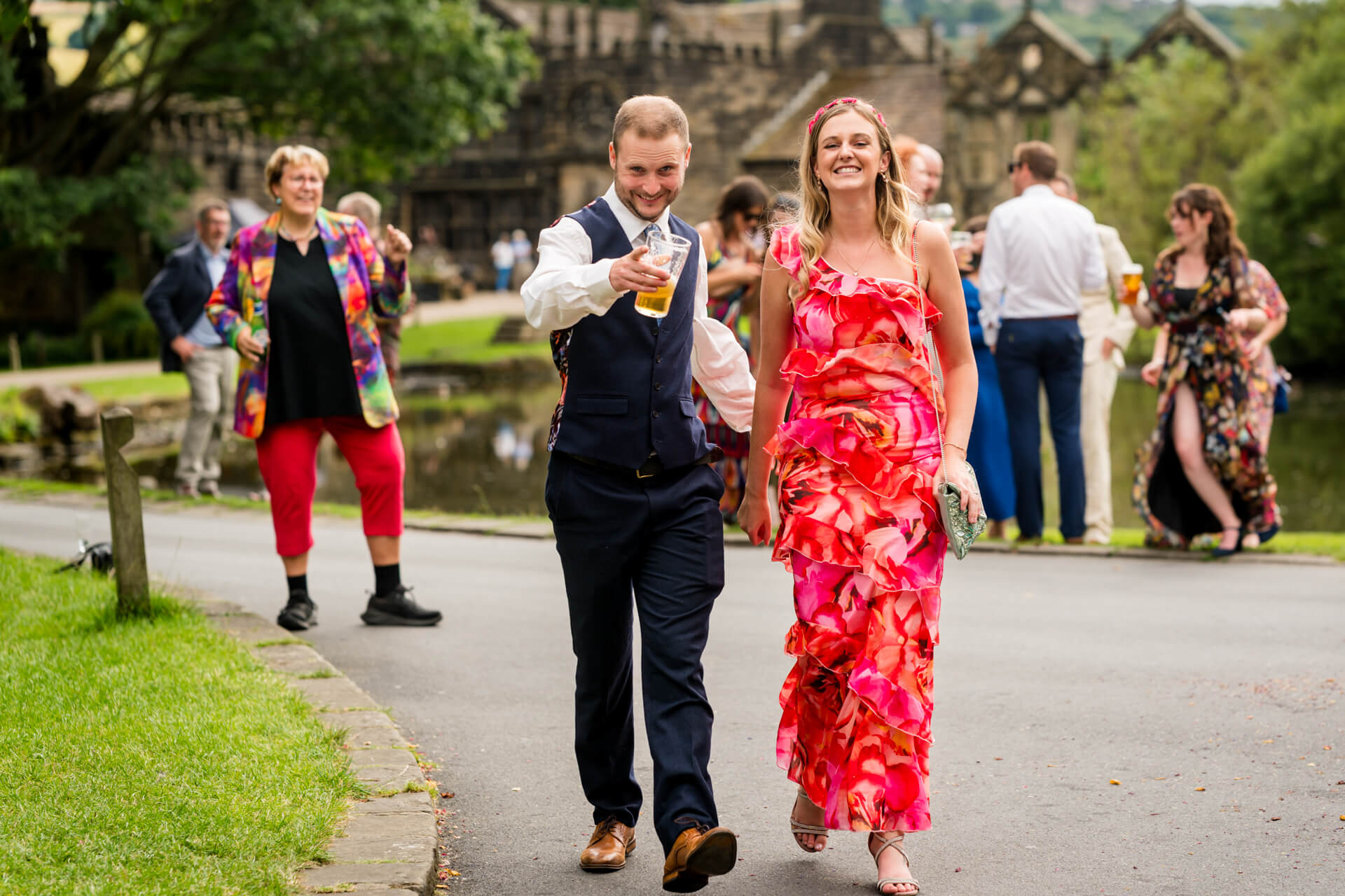 Couple walking joyfully at outdoor party with drinks