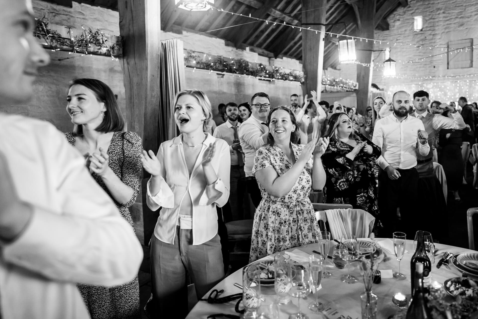 Guests clapping joyfully at a wedding reception