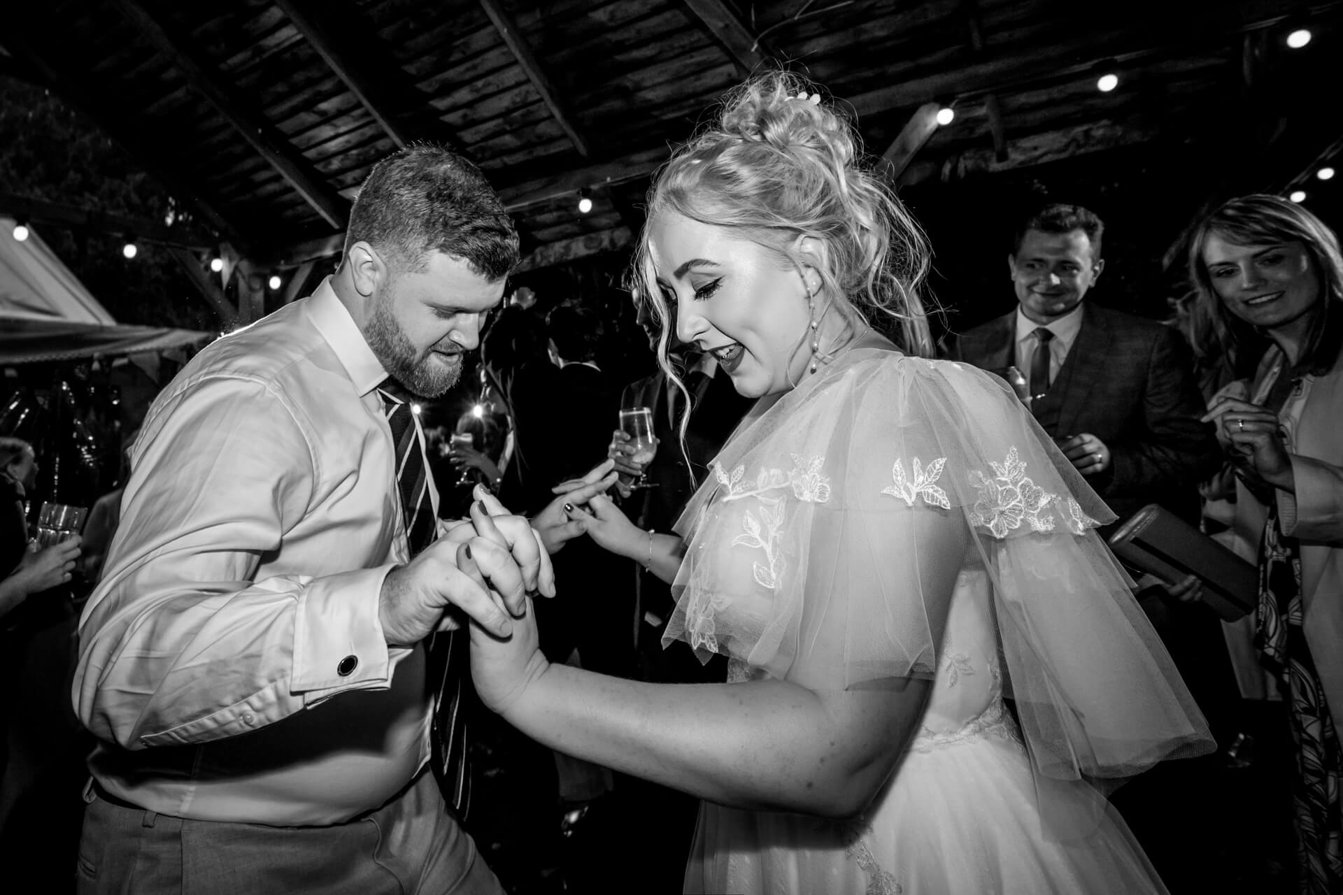 Bride and groom dancing joyfully at wedding reception