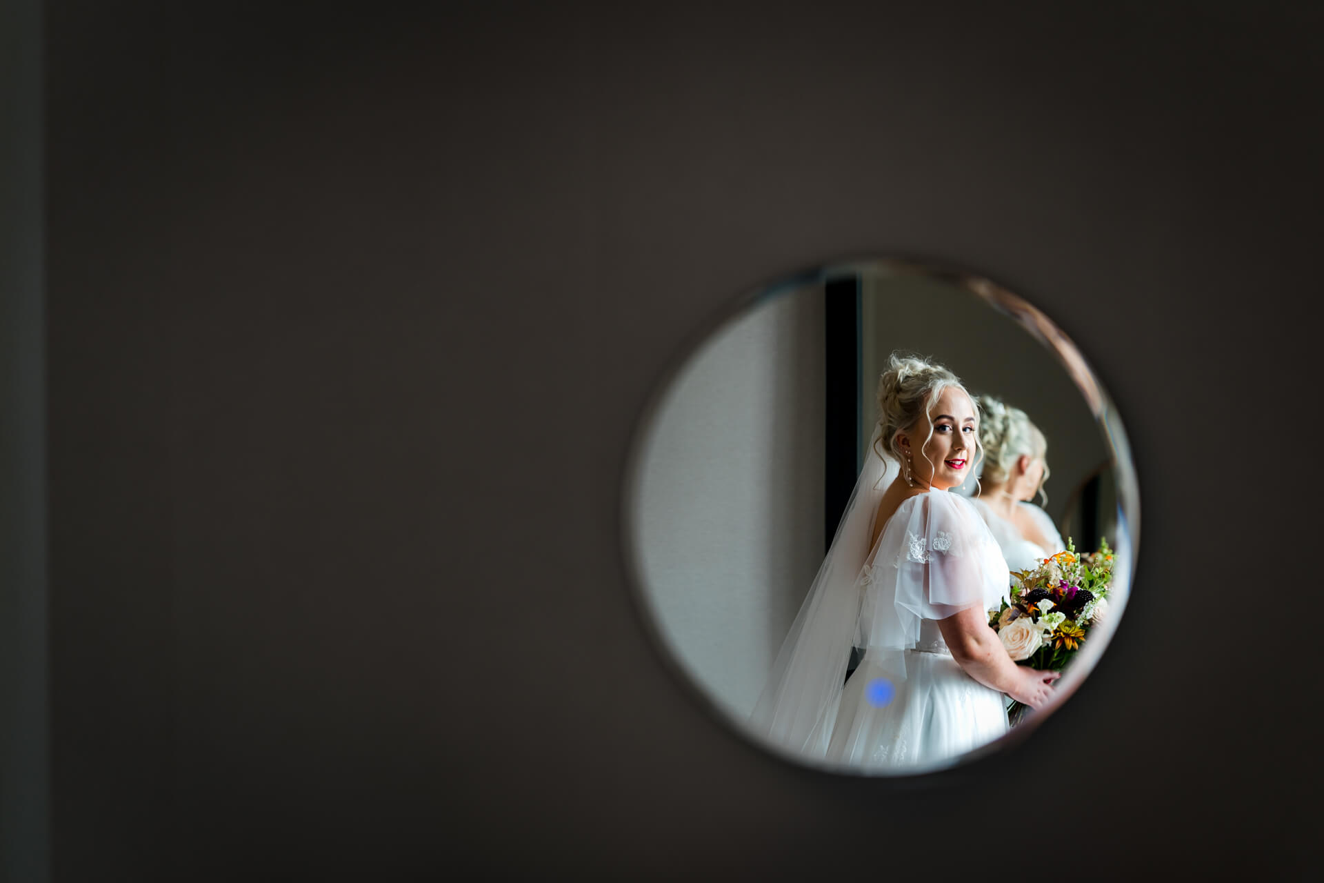 Bride reflected in mirror holding bouquet