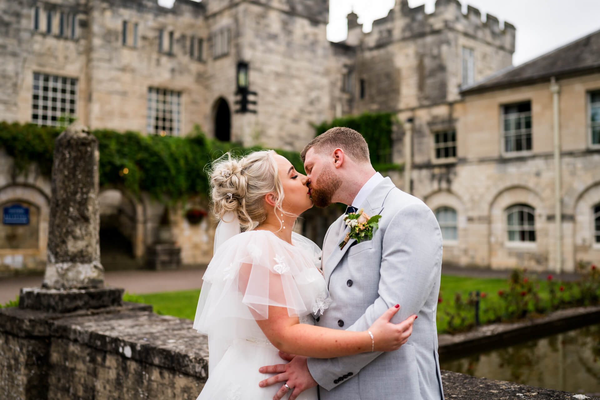 Bride and groom kissing in front of Hazlewood Castle