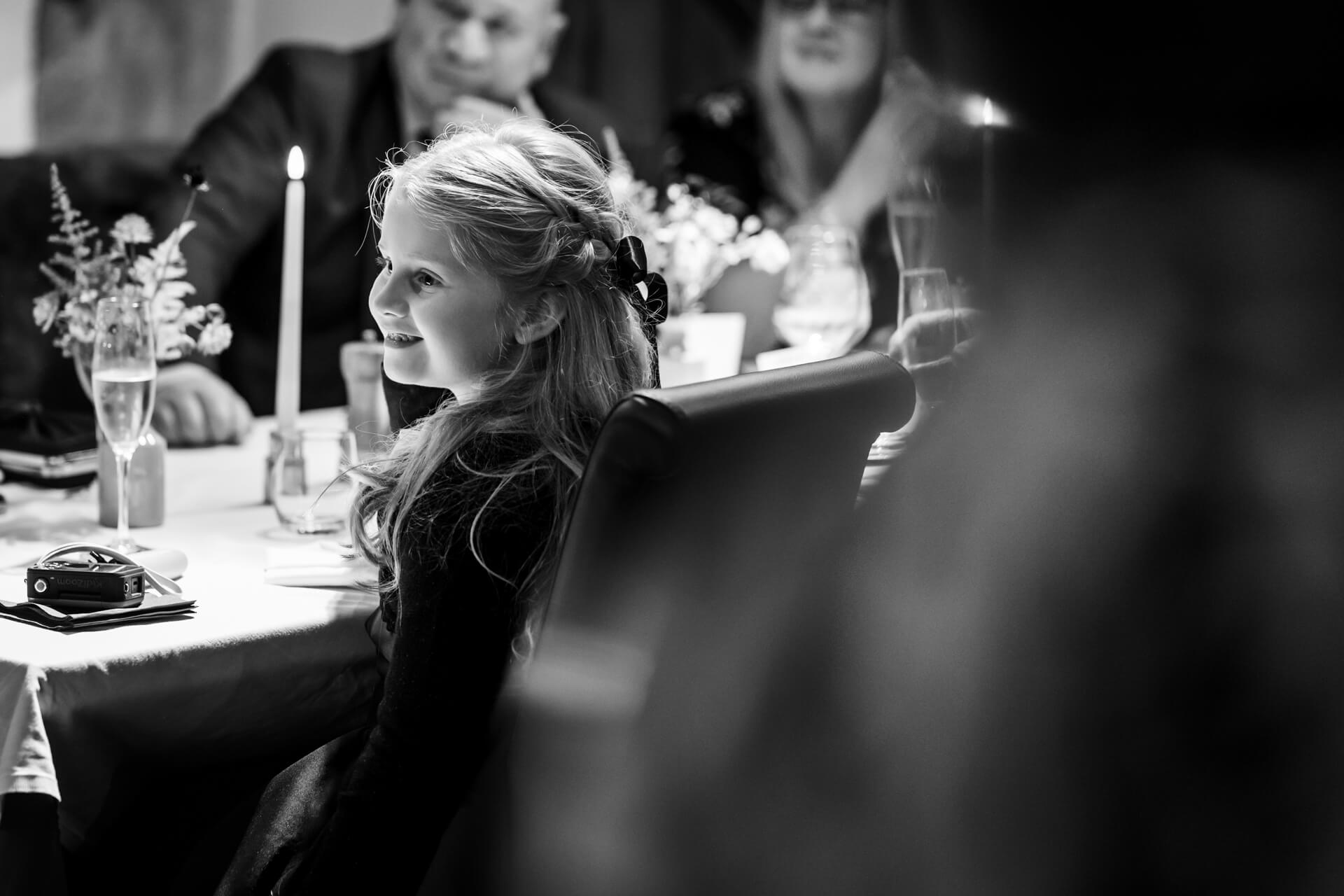 Young girl smiling at festive candlelit wedding dinner party