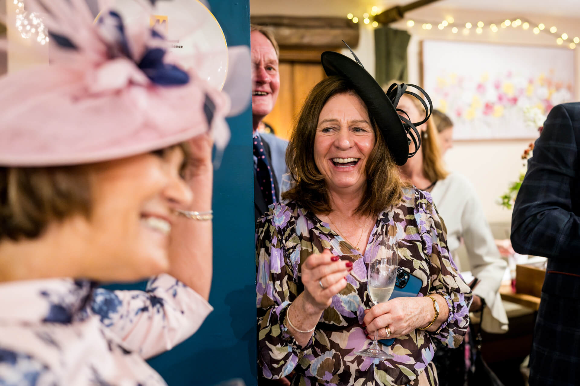 Joyful lady in floral dress laughing at festive event